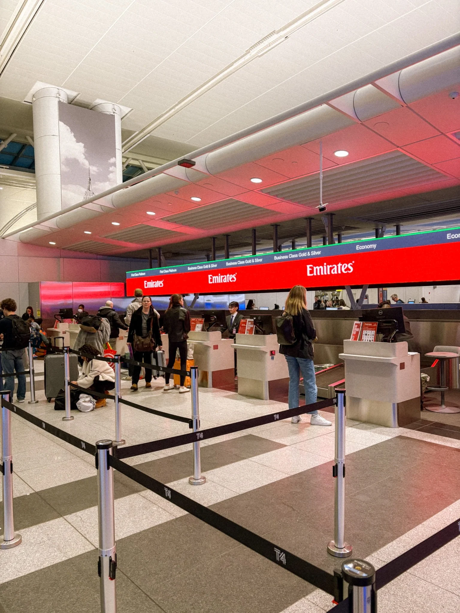 Emirates check-in counter at JFK Airport in New York showing First Class, Business, and Economy lanes