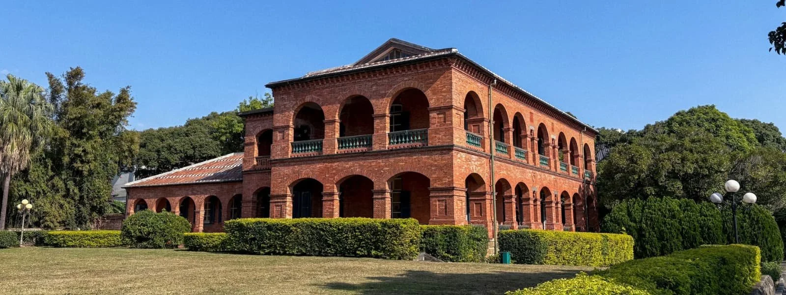 Two-story red brick British Consular Residence with arched verandas beside Fort San Domingo