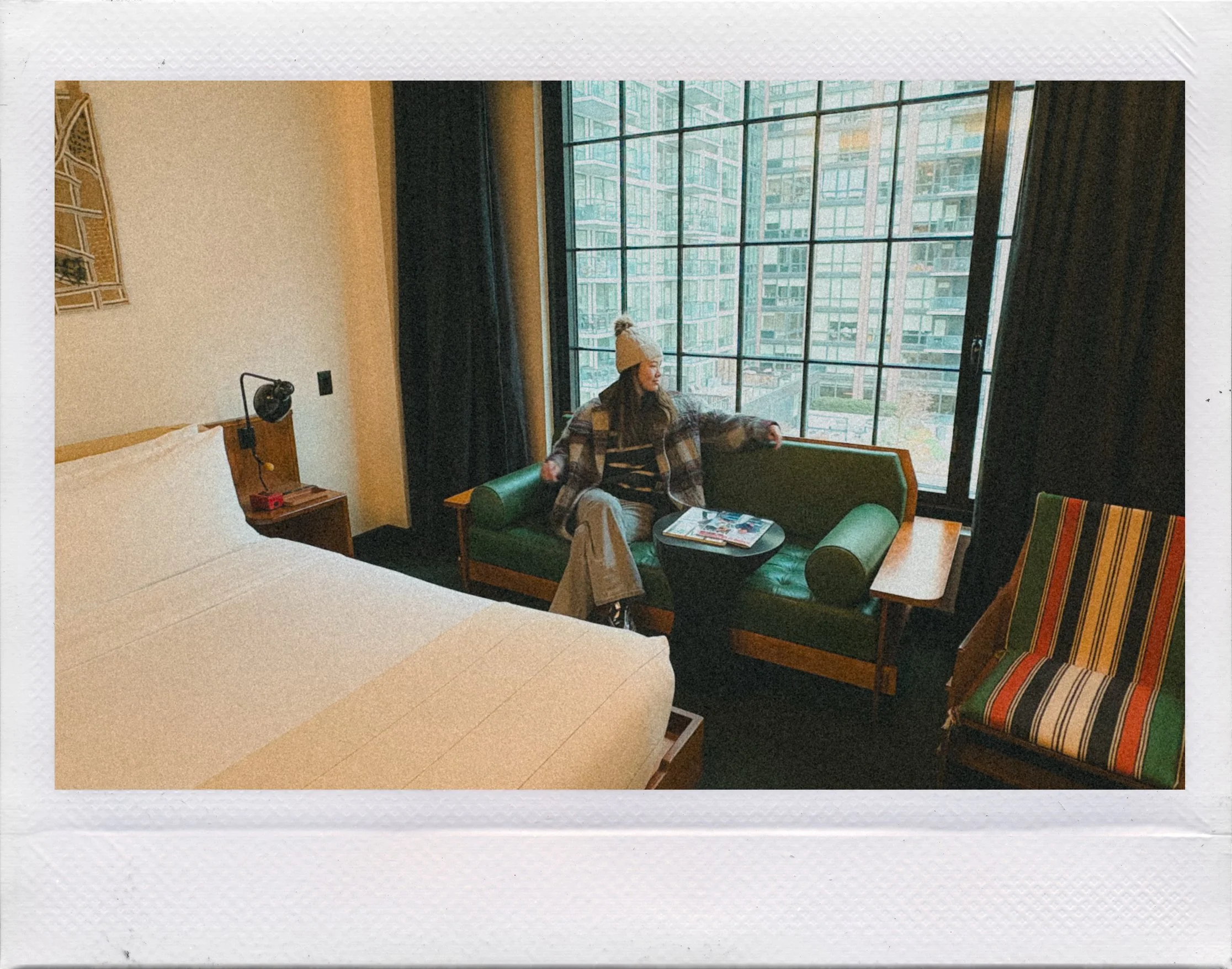 Guest relaxing on a green couch by the window inside a room at Ace Hotel Brooklyn, highlighting a calm boutique hotel stay