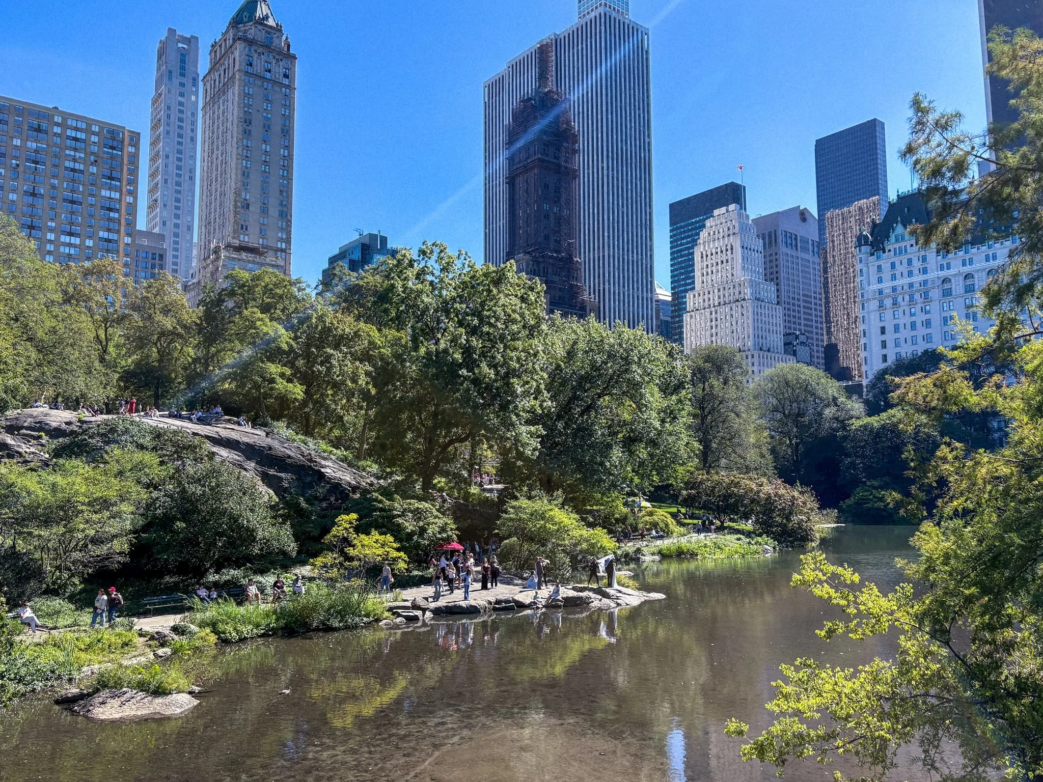 The Lake in Central Park with Manhattan skyscrapers rising above the trees