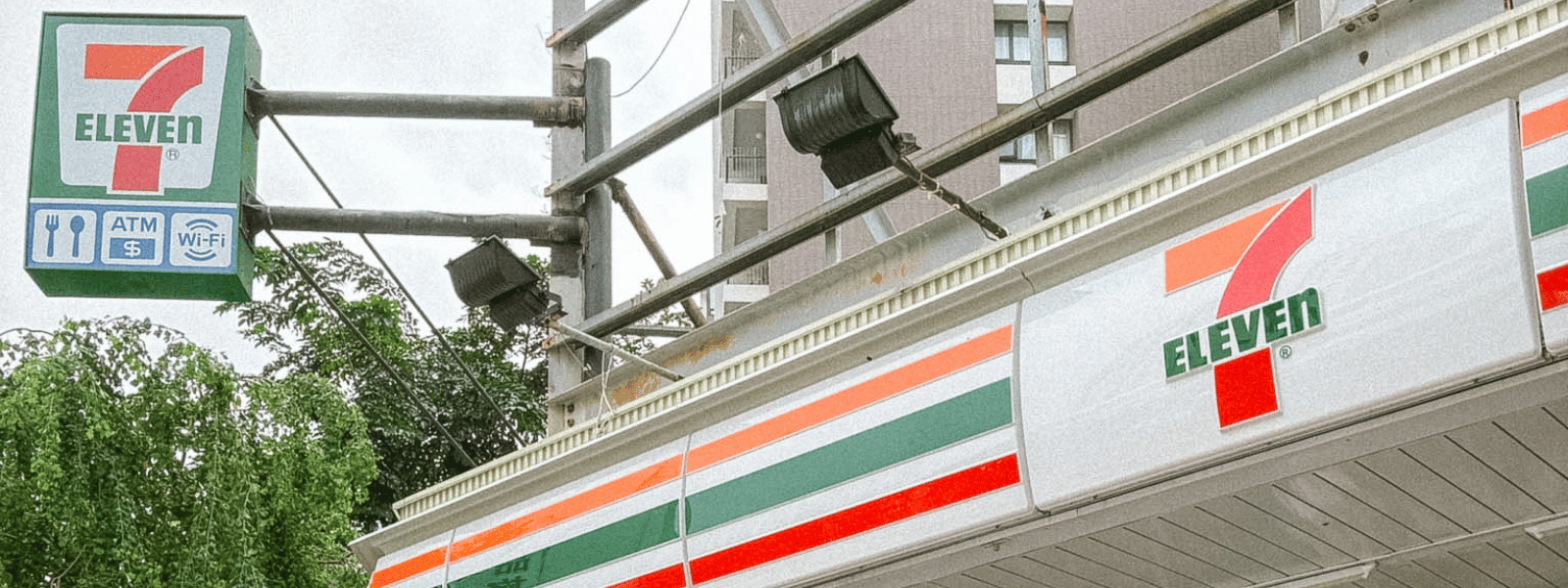 7-Eleven convenience store sign in Taiwan showing ATM, food, and Wi-Fi services available inside