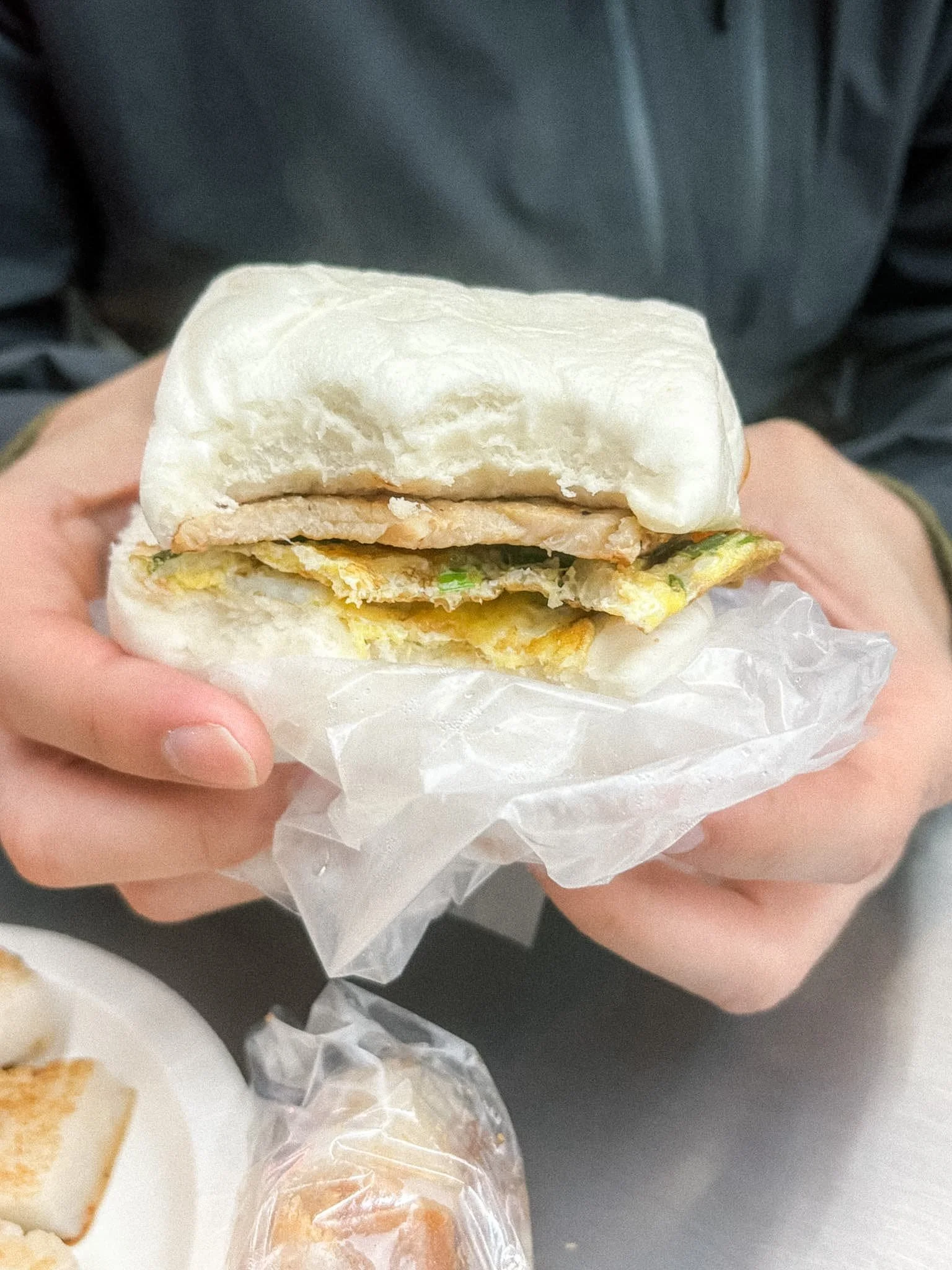 Steamed bun sandwich with pork cutlet and scallion egg at a Taiwanese breakfast shop