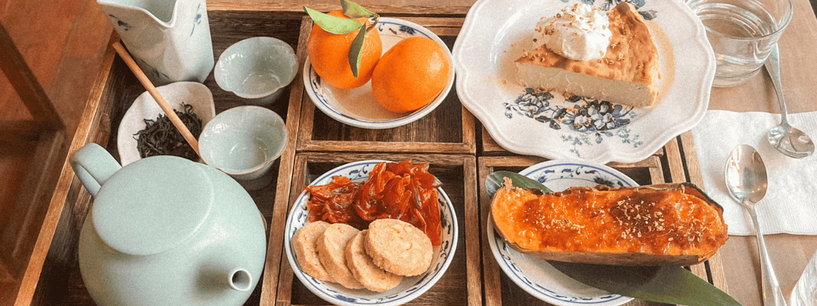 Chinese afternoon tea set with teapot, oranges, sweet potato, and cookies at Duo Cafe in NYC
