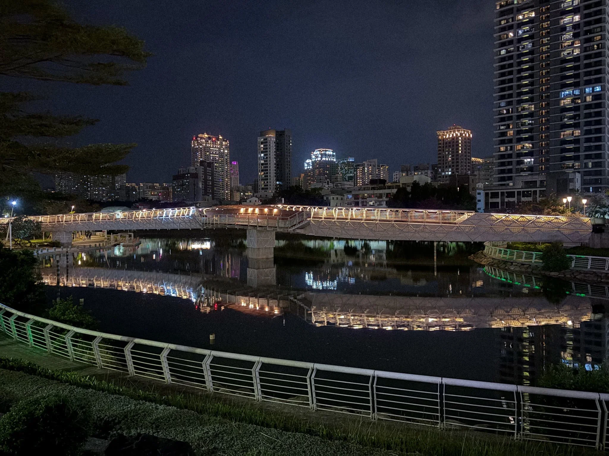 Love River Kaohsiung at night with illuminated bridge reflecting in the water and city skyline