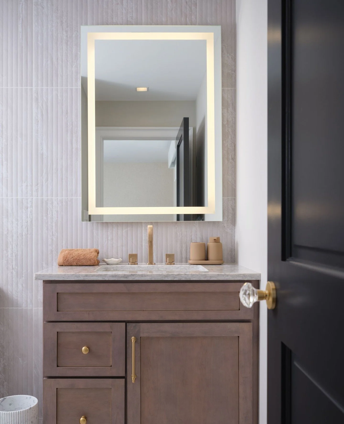 Guests may never leave, and we can't really blame them.⁠
⁠
Reeded tile, quartz, warm brass, and just enough contrast make this guest bath one of our favorite little moments in the home.