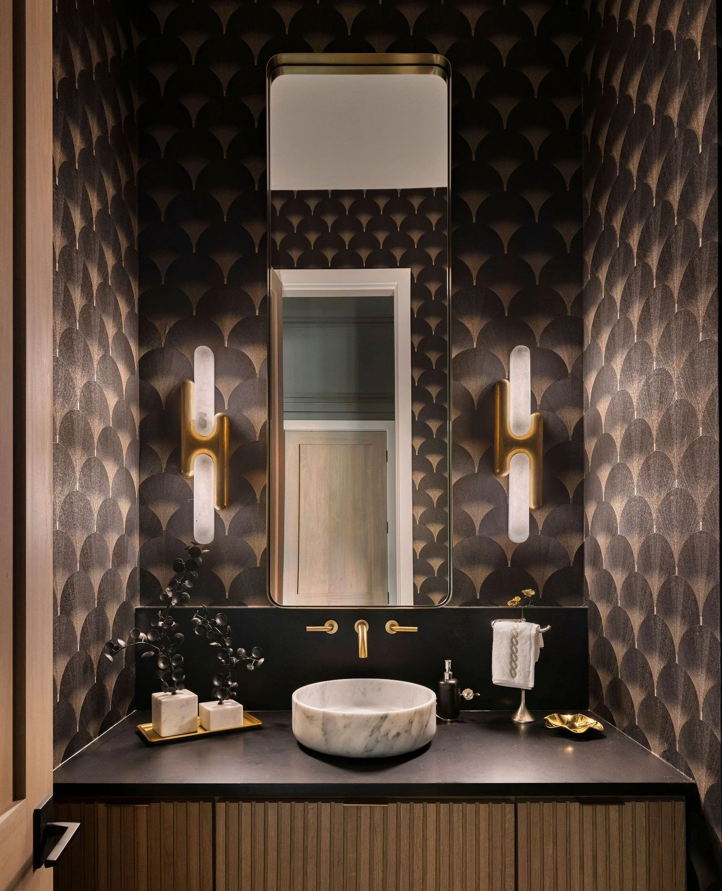 This might be the smallest room in the house, but that doesn&rsquo;t mean we like to play it safe! 🖤⁠
⁠
We treated this powder room like a little jewel box, wrapping it in a dramatic @phillipjeffriesltd wallpaper and letting the sculptural @aloralig