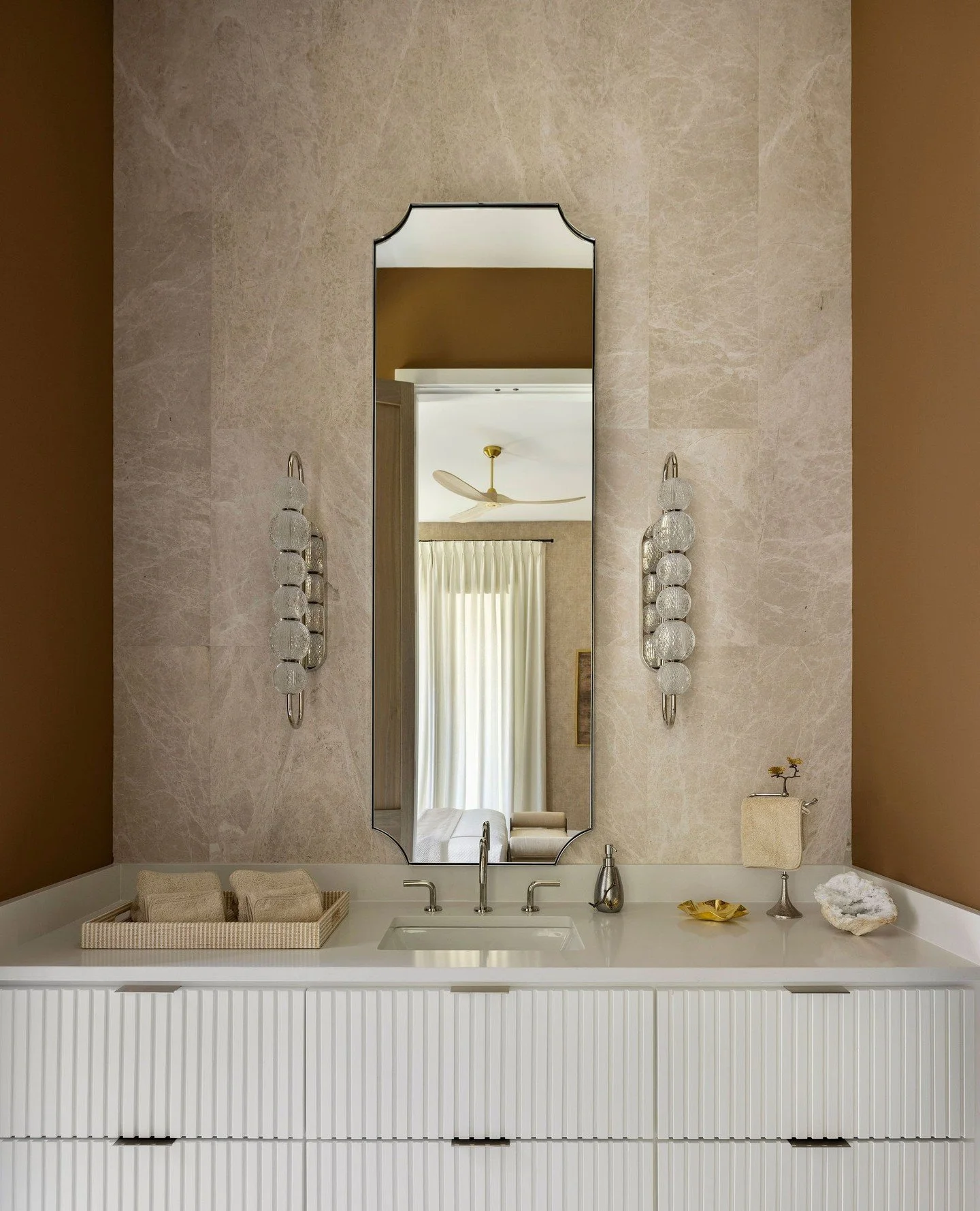 A little bit modern. A little bit Tennessee. 🤎⁠
⁠
We started with the clean lines of the reeded vanity, then warmed things up with @sherwinwilliams Toasty and carried tile all the way up the vanity wall for another layer of texture.⁠
⁠
The @sanderso