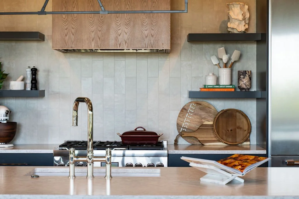 Image showing kitchen decor/design featuring a cookbook, wooden cutting boards, ceramic cookware, a gas stove, stainless appliances and a wooden range.