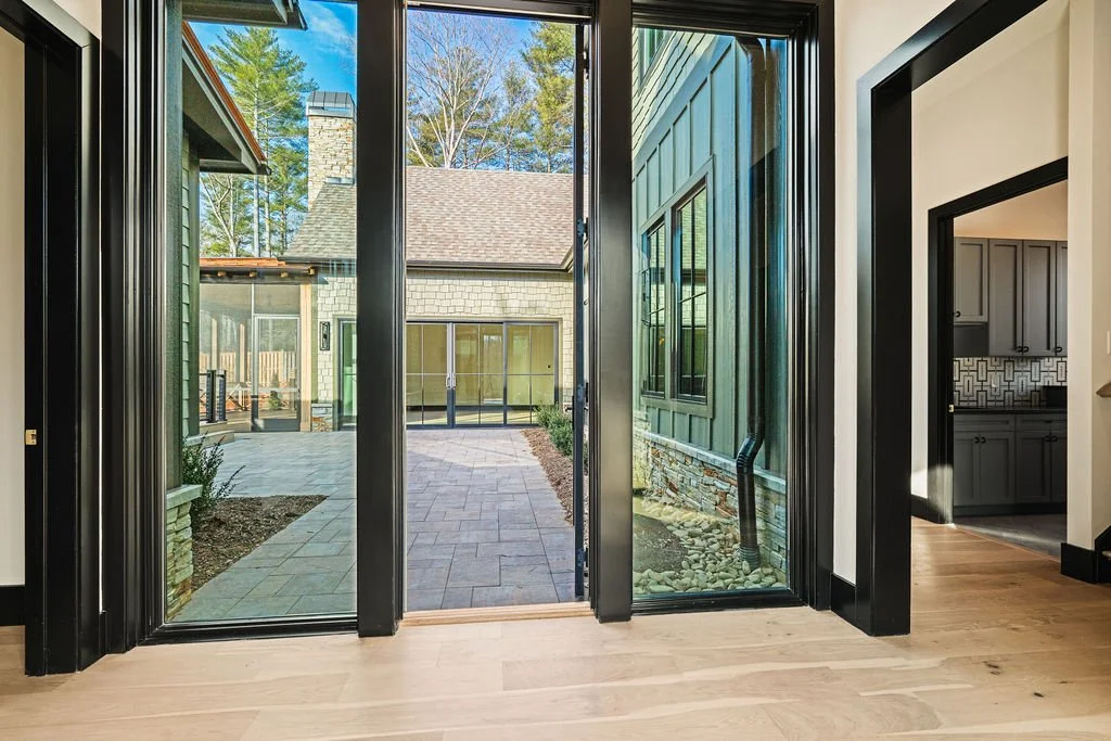 Large glass windows with open door looking into a courtyard.