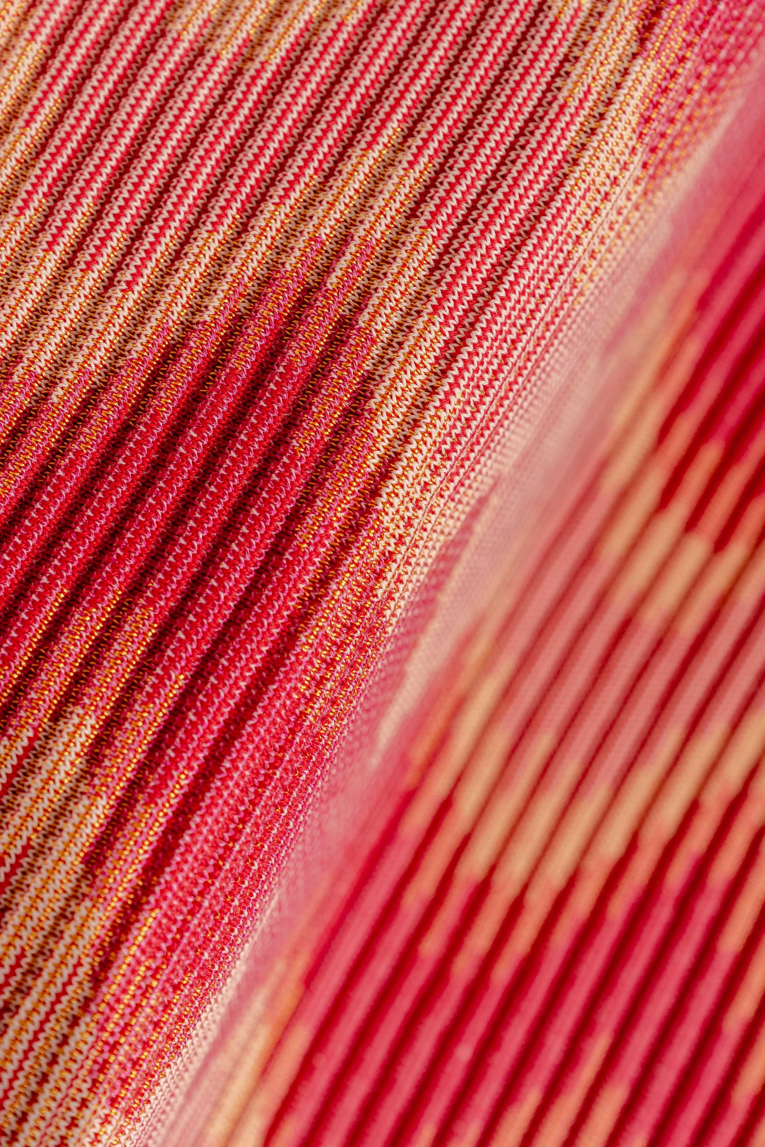 Close-up view of a stack of pink and red striped fabric with glittery accents.
