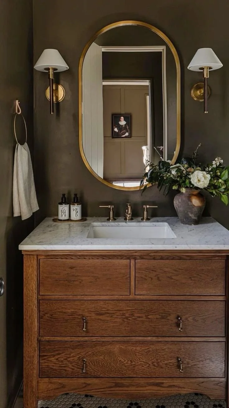 Moody powder room with dark paint, statement mirror, and dramatic lighting in modern luxury home design