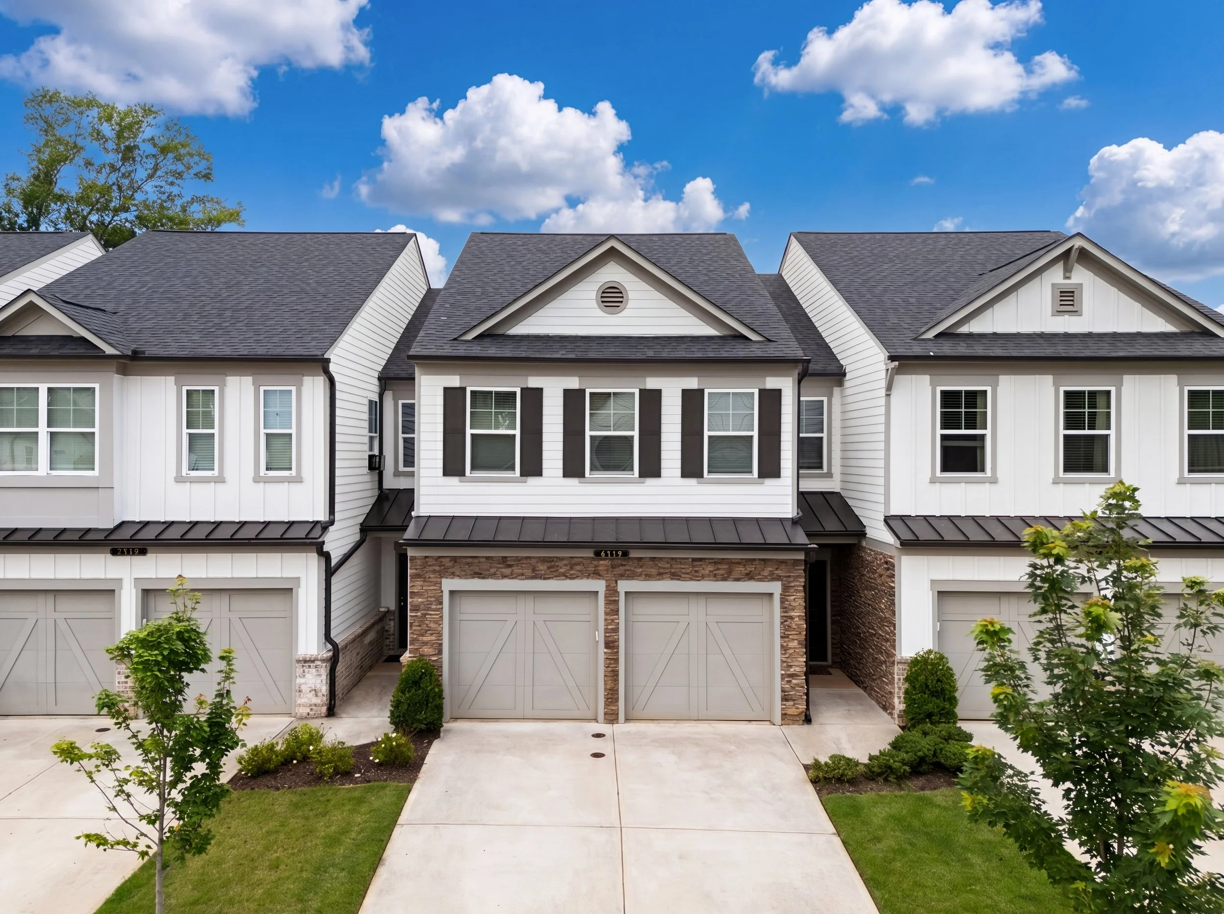 Exterior of 6165 Langdon Way, a Brookview townhome in Cumming, GA with a two-car garage, new roof, white siding, stone accents, and landscaped front entry.