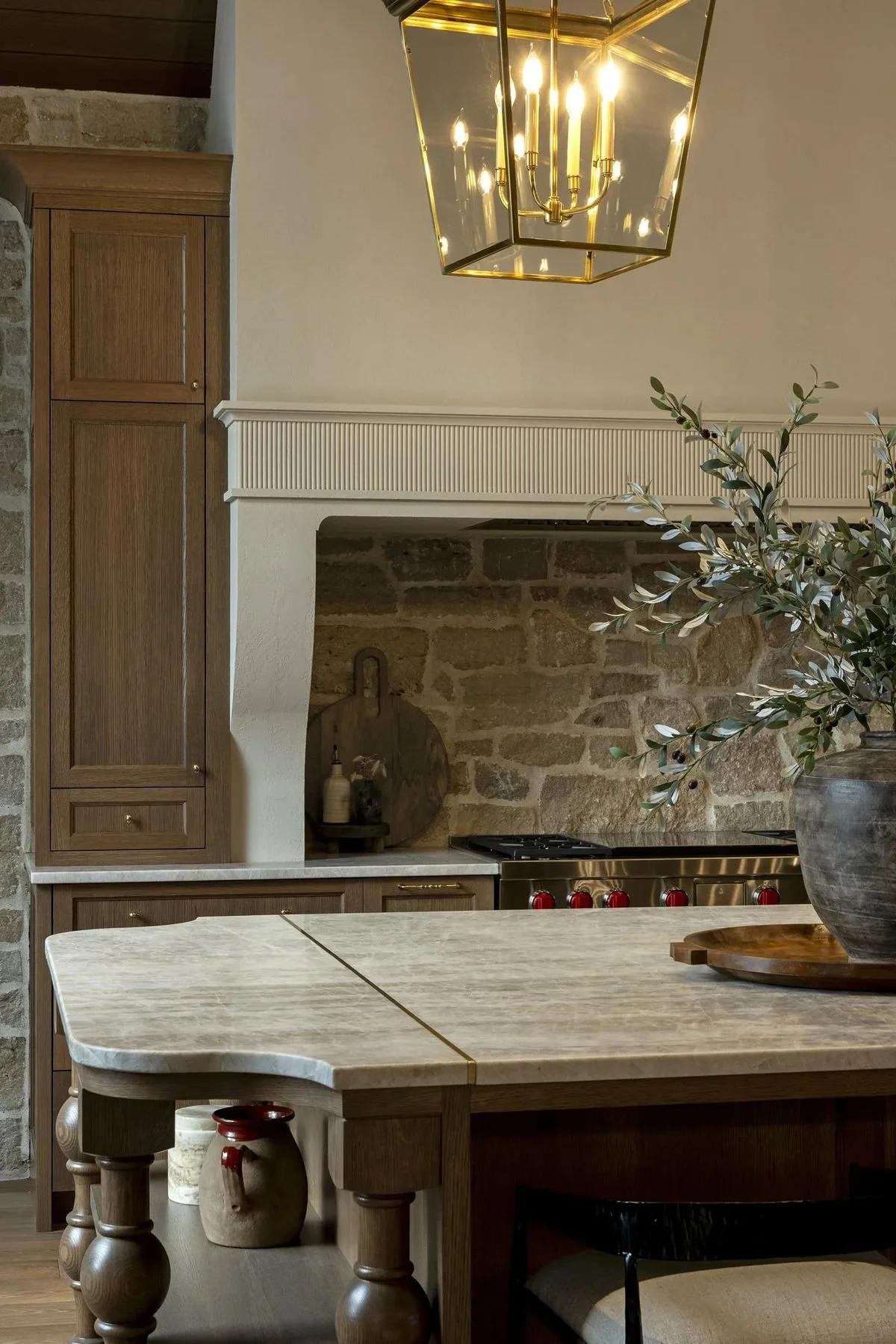 European inspired kitchen with warm cabinetry, natural stone, and soft neutral colors trending in modern homes