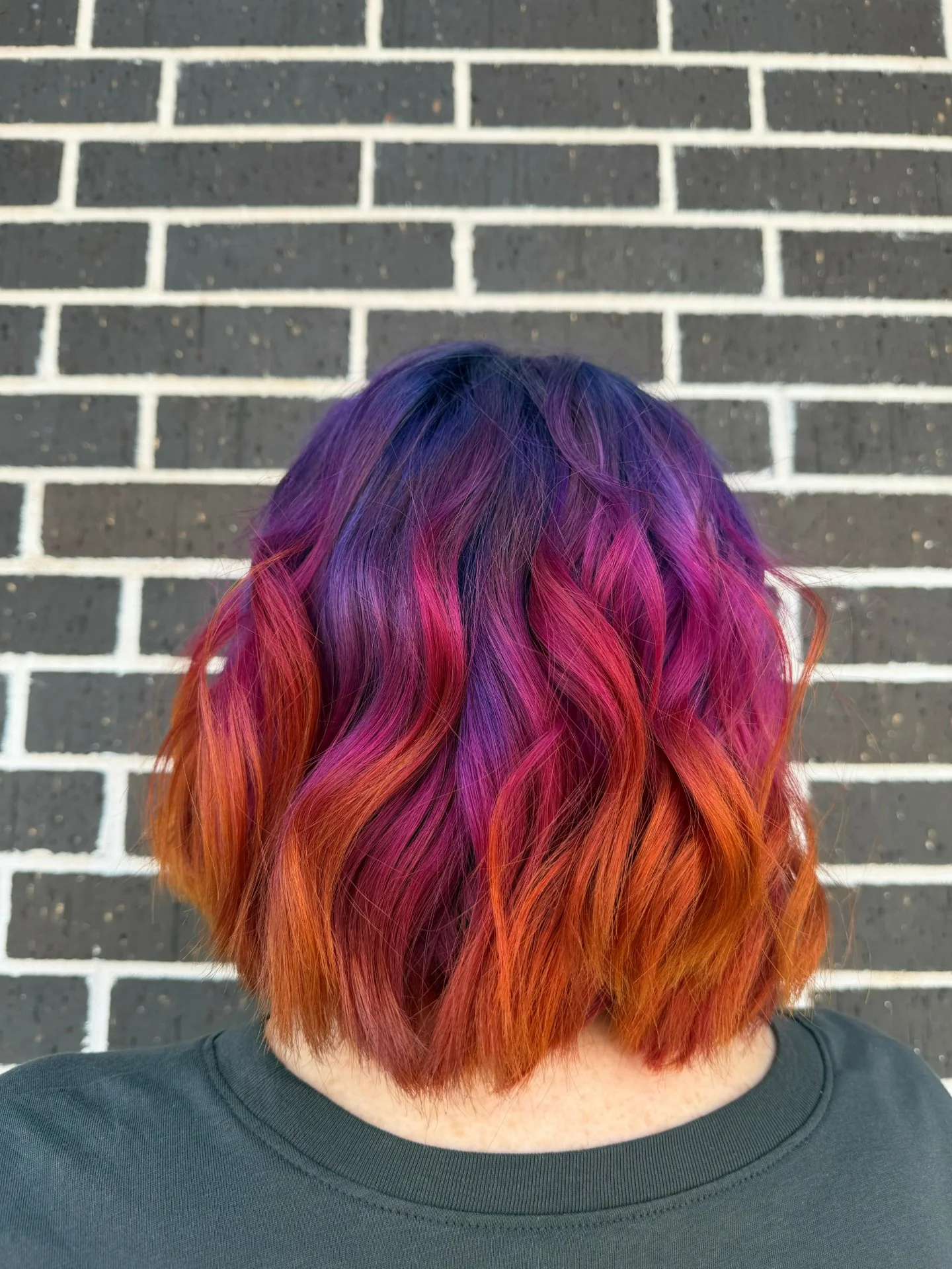 A sunset, but make it hair. 🌅💜🧡💗

Purple, orange, and pink all blended together for the prettiest sunset moment.

Want your vivid color to stick around longer? Wash less often, use cool water, and make sure your products are color-safe. Heat styl