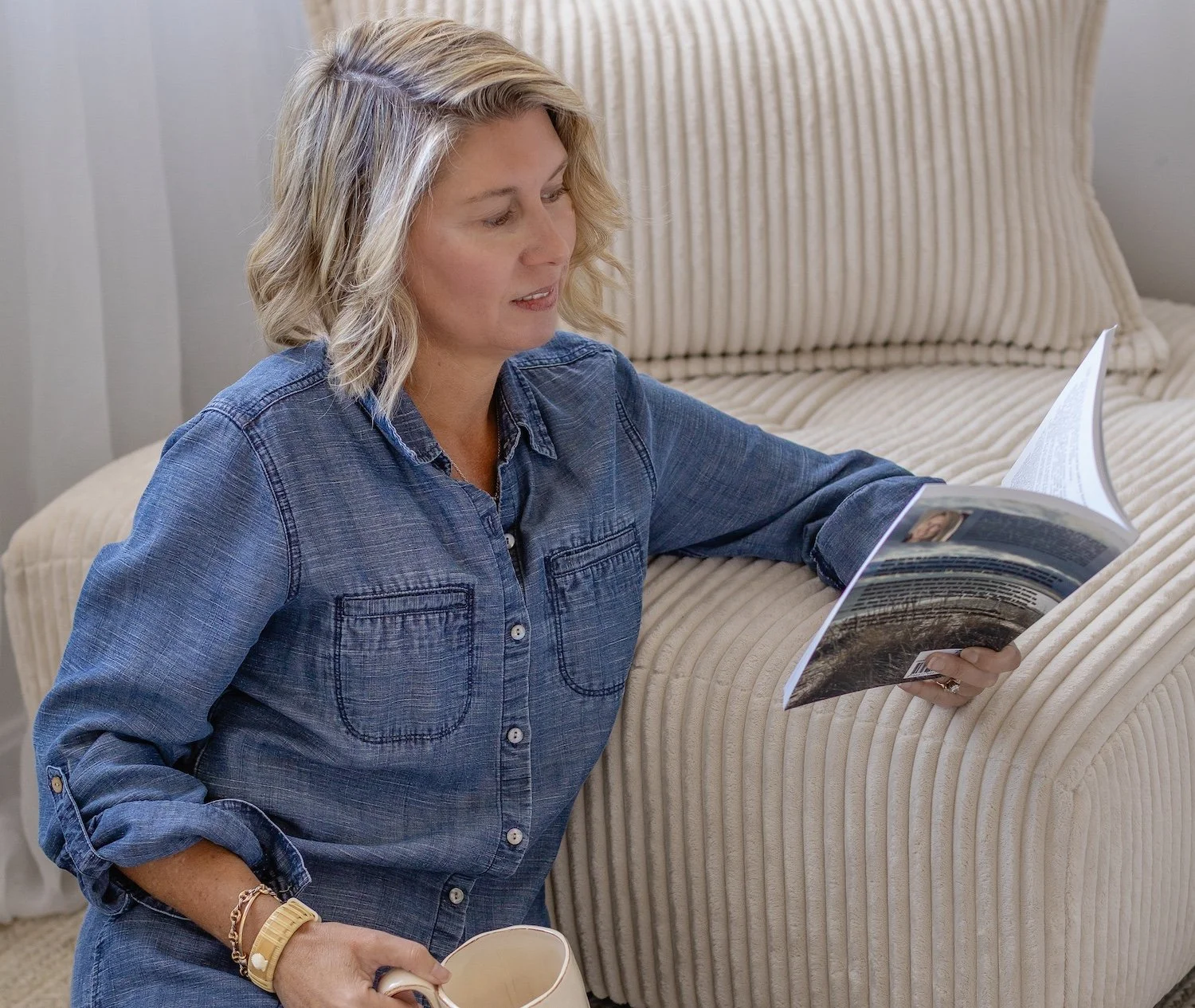 blonde lady reading book on floor