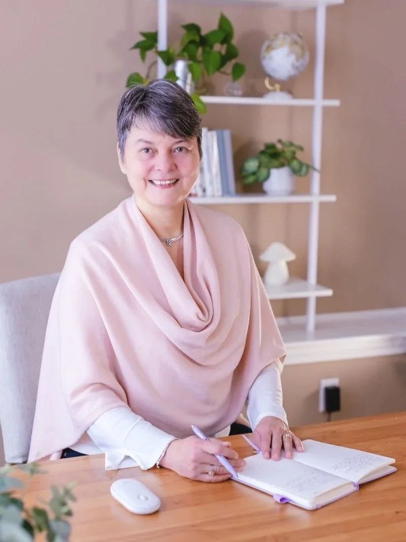 smiling-woman- in-pink-writing-at-desk