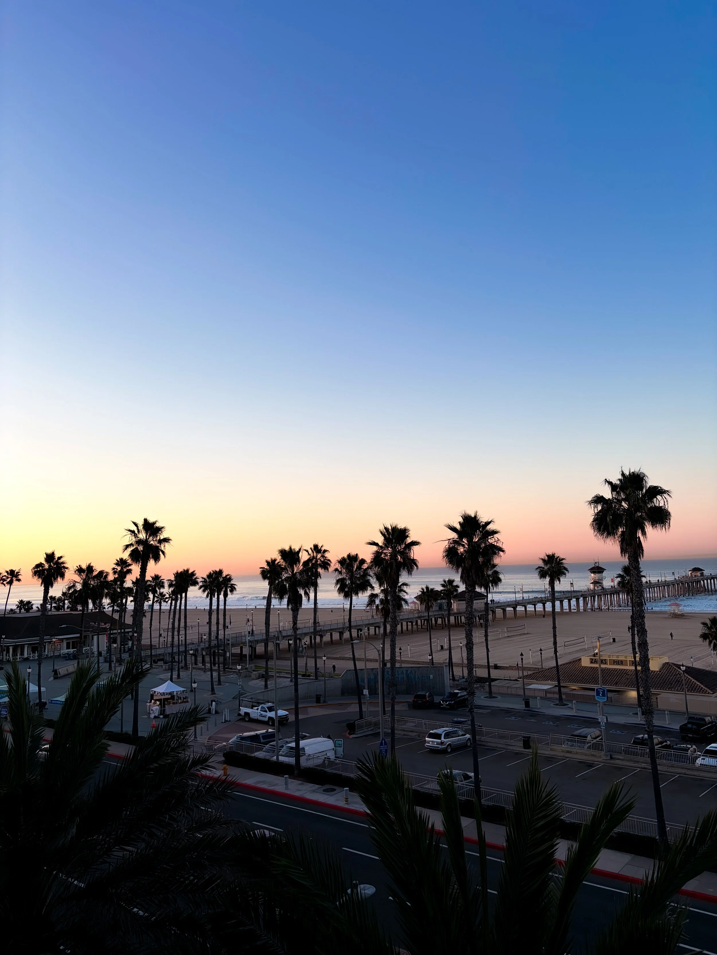 The sunset at Huntington Beach with palm trees