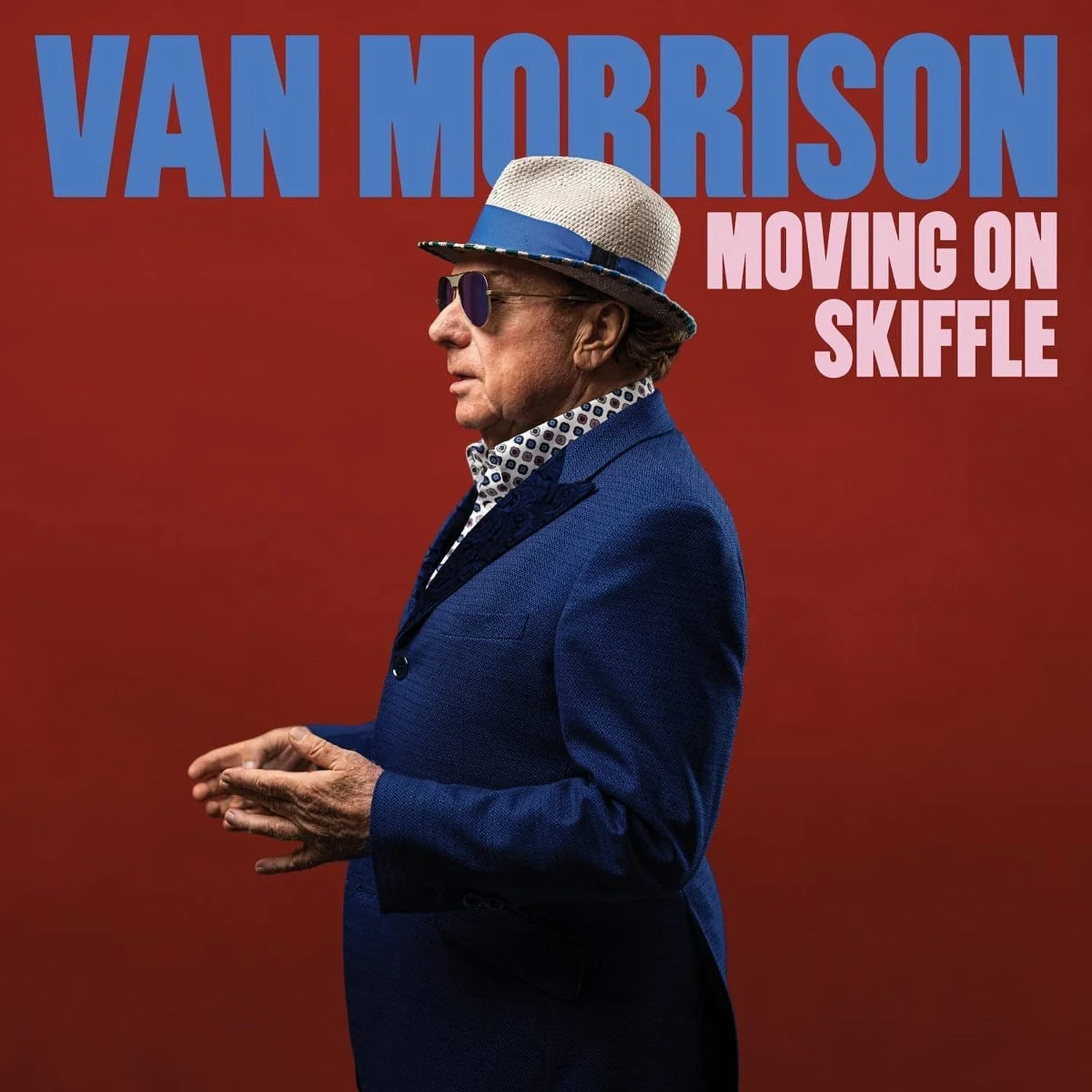 Album cover featuring Van Morrison in profile, wearing sunglasses, a patterned shirt, and a blue blazer, with a white hat with a blue band, against a red background. Text reads 'Van Morrison Moving on Skiffle'.