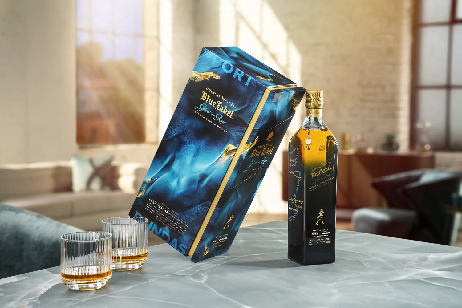 A bottle of Johnnie Walker Blue Label Scotch whisky and its packaging box with two empty glasses on a marble table in a sunny room with brick walls and large windows.