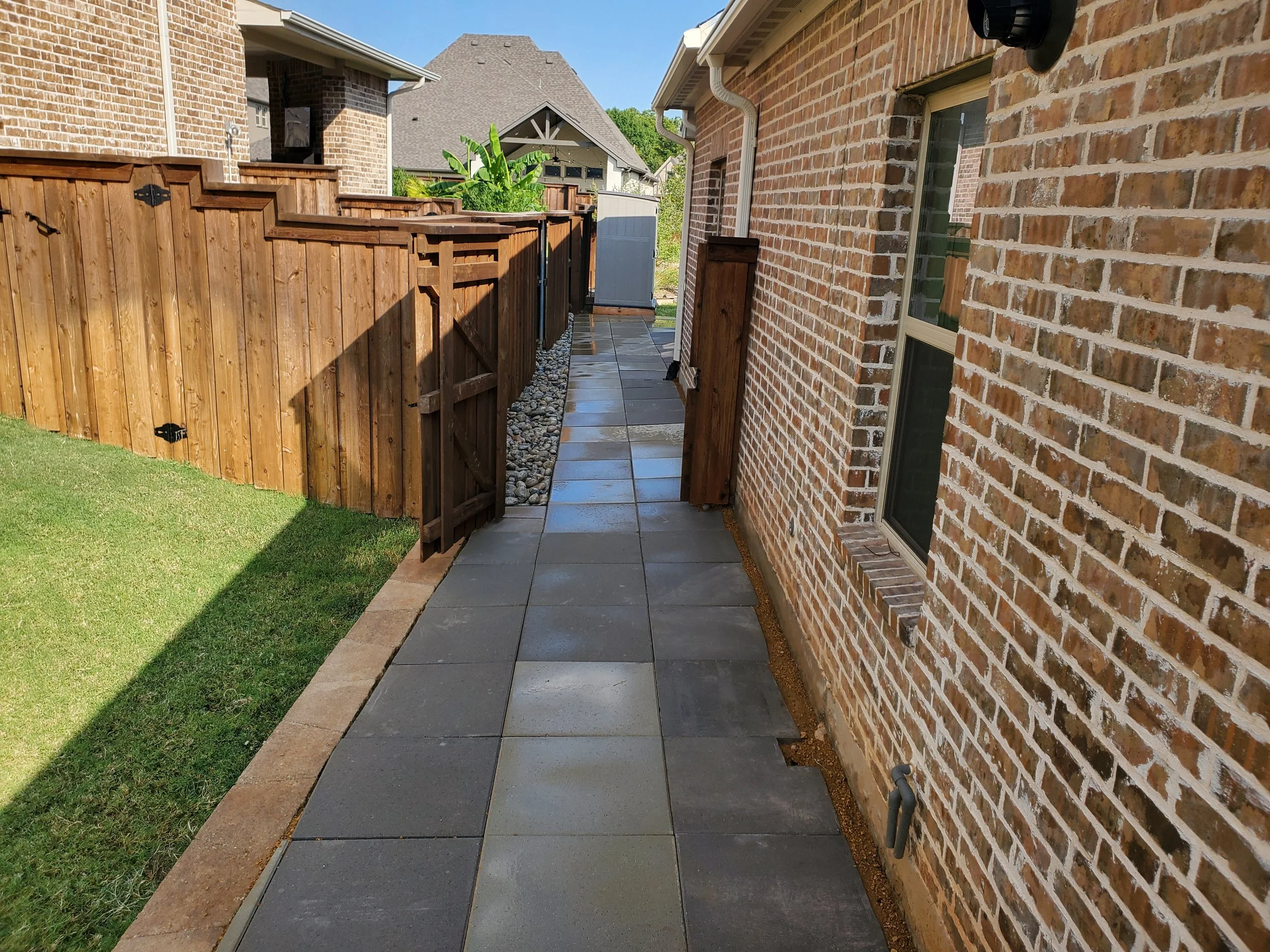 (Side Yard Angle) A concrete paver walkway that wraps entirely around the house, starting from the front driveway and ending all the way at the back porch. This replaced a decomposed granite walkway with minimal pavers that left a mess everywhere.