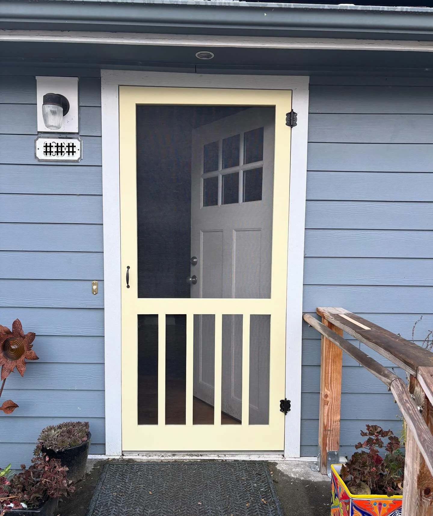 This soft butter yellow with a classic design blends right in with the home’s welcoming feel and quiet curb appeal. Swipe to see the full picture - a cozy cottage home with a solar-powered roof, a charming picket fence, and now a screen door to