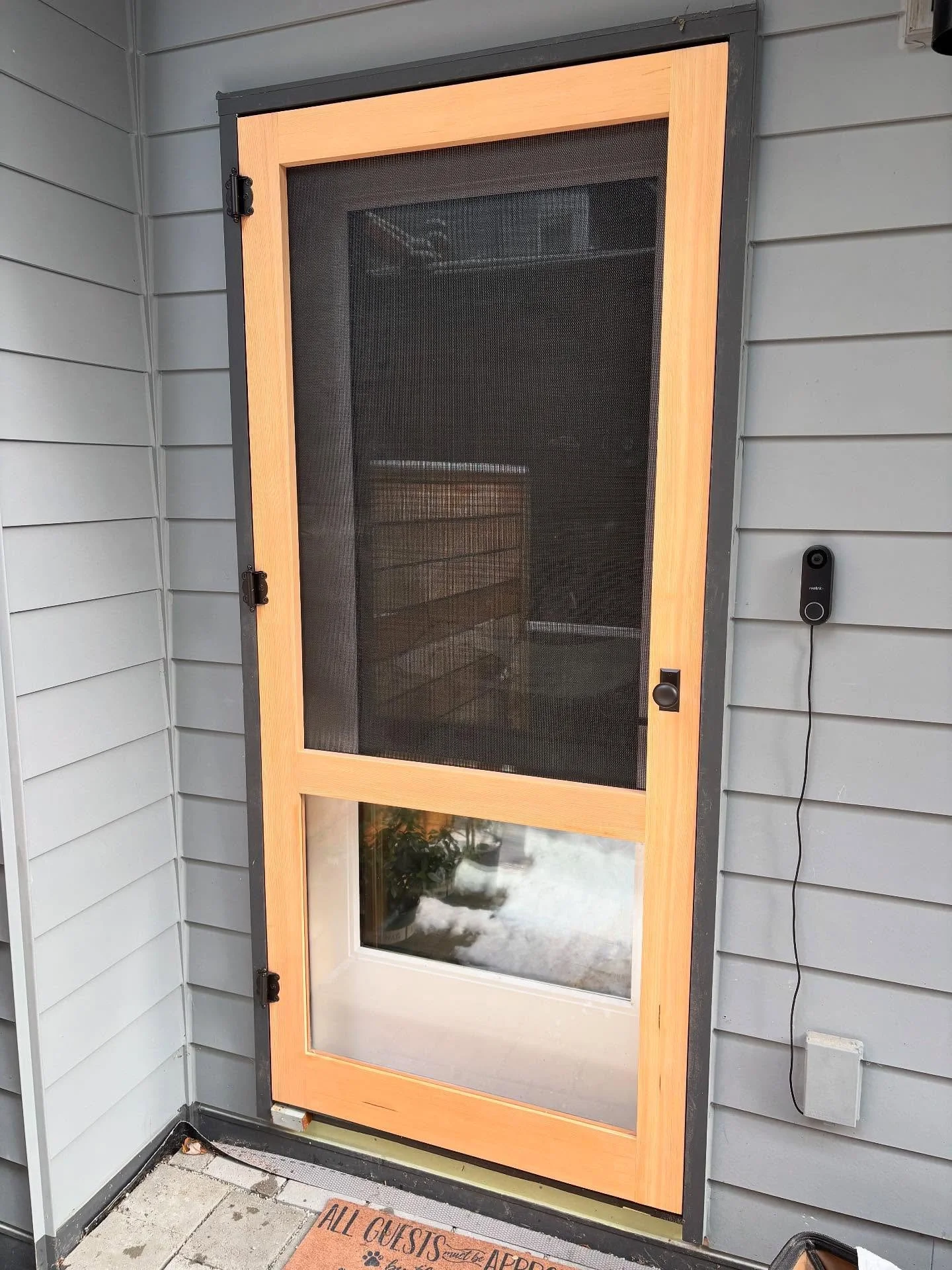 A screen door with a view, even for the cats!
This custom build has a clear plexiglass lower panel so the feline residents can keep an eye on the backyard action without scratching the mesh. A cozy solution for a sweet patio and some very lovingly sp