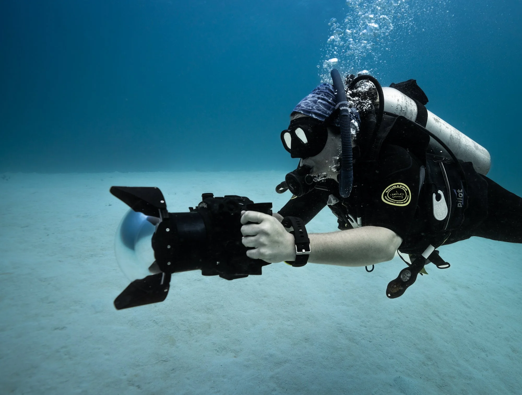 A scuba diver underwater taking photos or video with a waterproof camera.