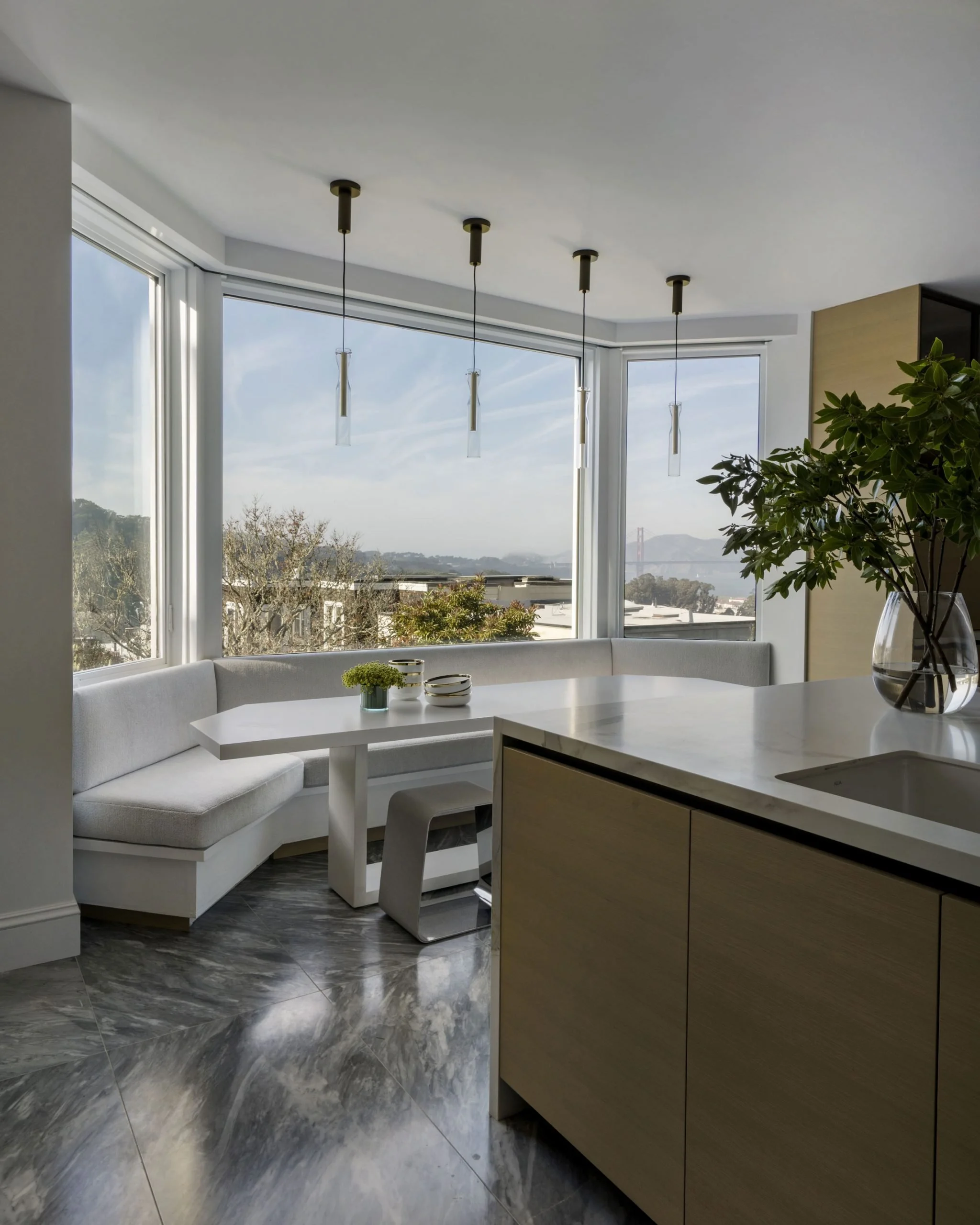 Golden Gate bridge view from a Pacific Heights post war remodel, modern kitchen with banquet seating in bay window.  