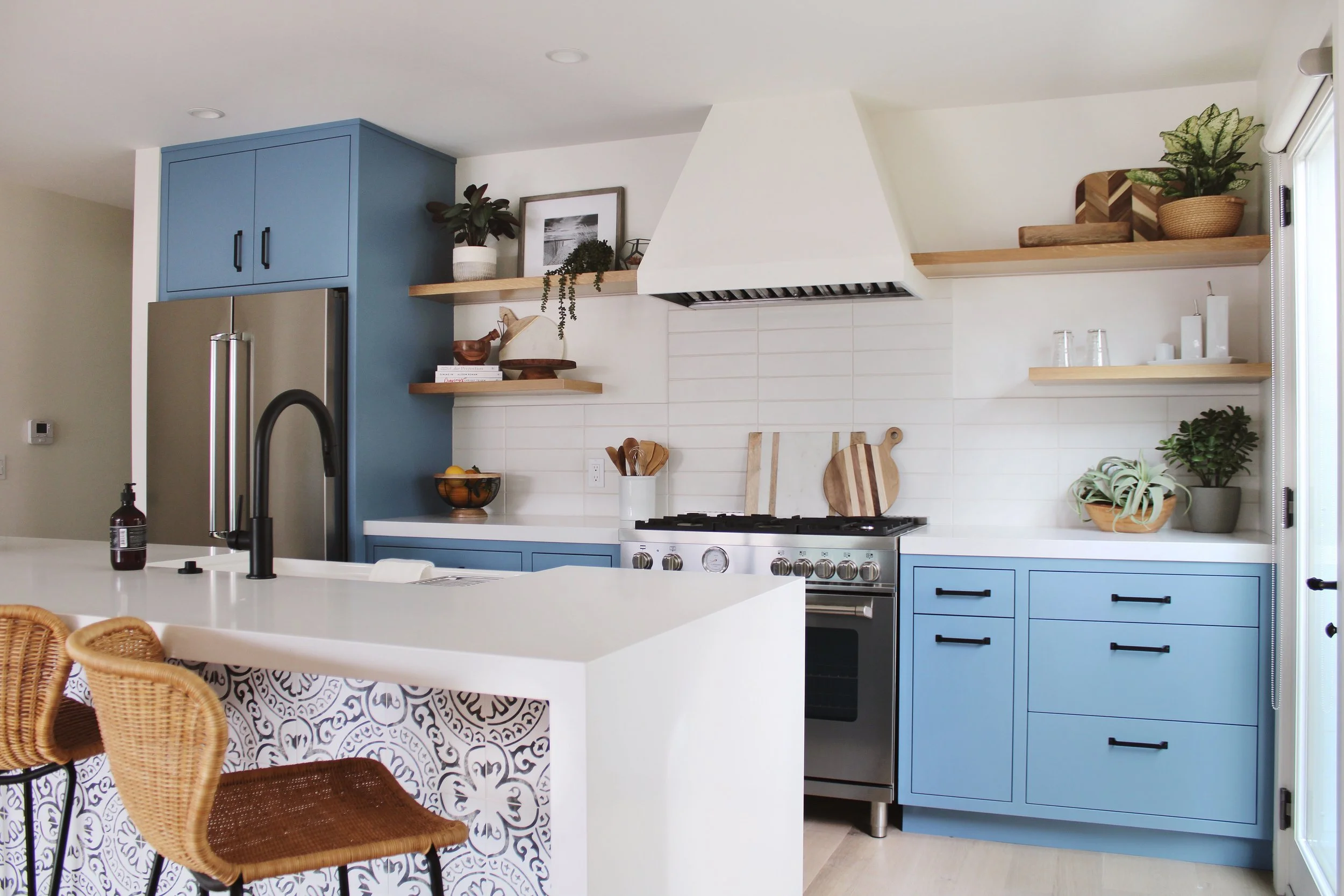 Contemporary kitchen featuring light blue inlay cabinets, open shelving with styled accents, and sleek, minimalist finishes