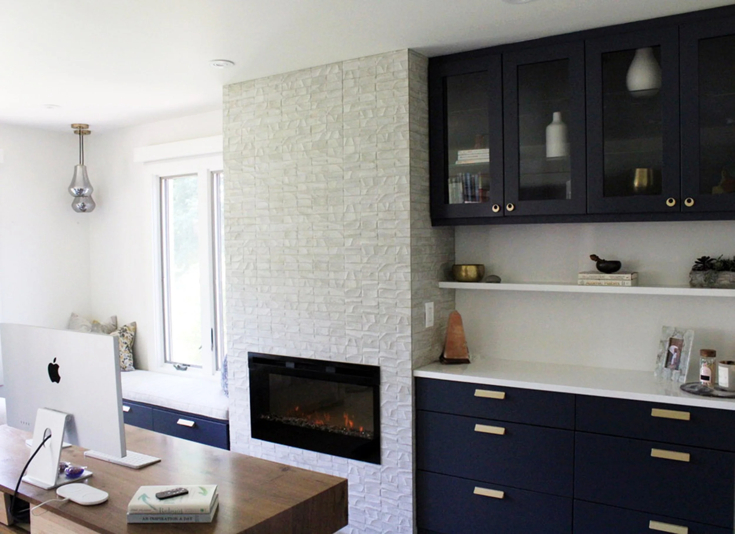 Home office with modern frameless dark blue cabinetry and a tiled fireplace, featuring sleek, contemporary design