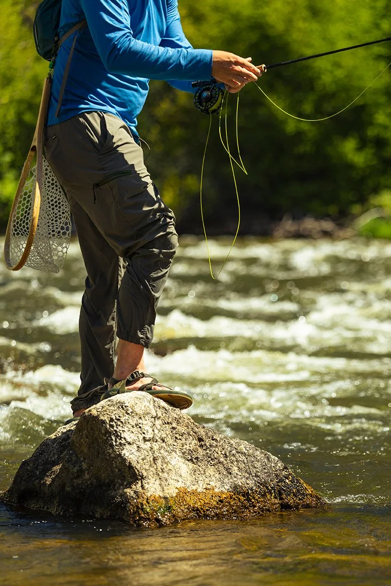 fly fishing lifestyle legs chacos river rock sandals standing.jpg