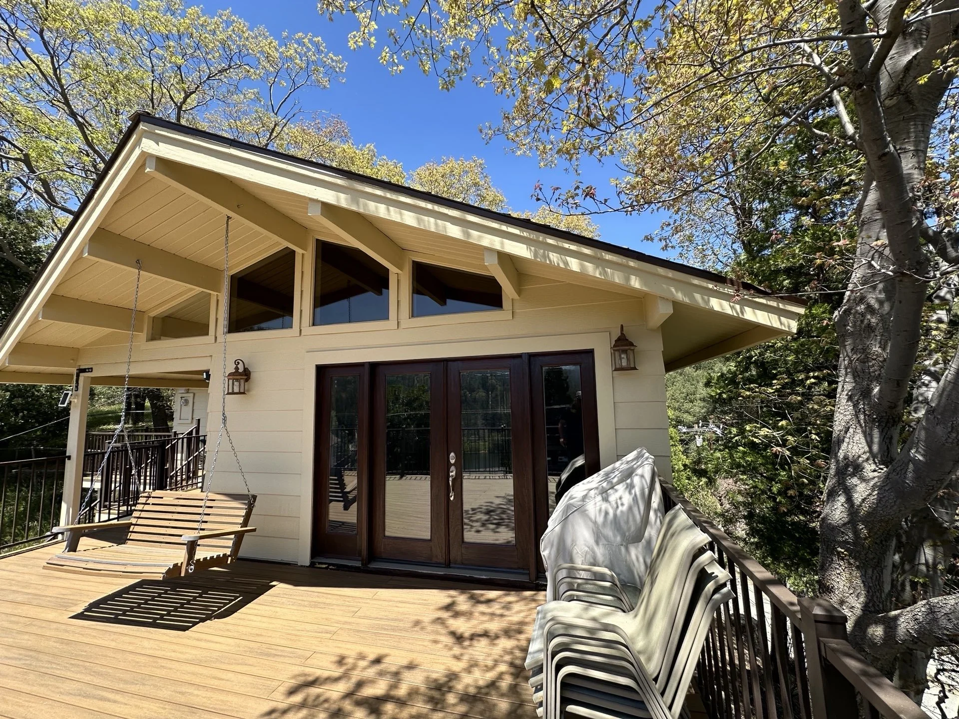 A person installing white ceramic tiles on a wall near a wooden countertop, with adhesive visible on the wall.