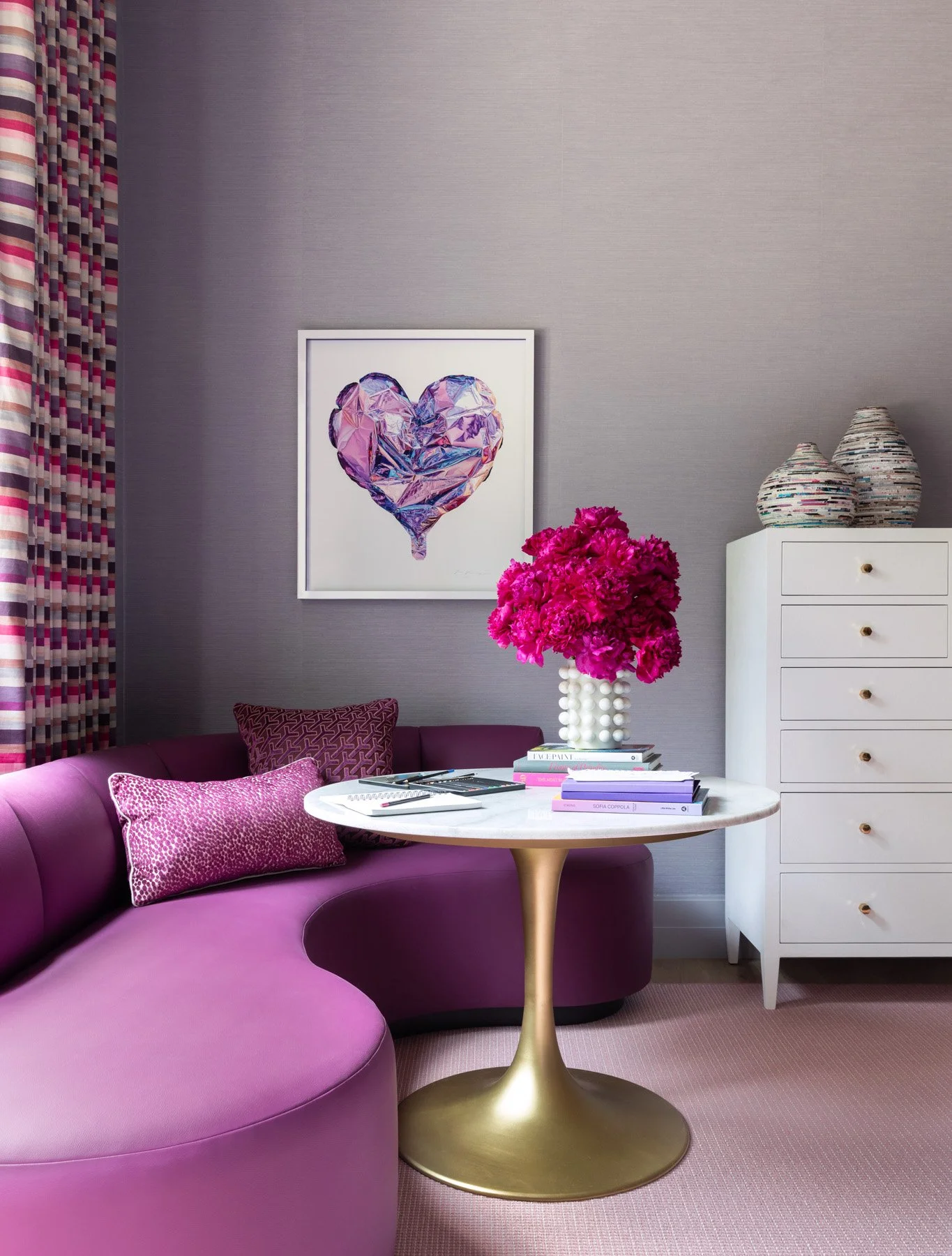 Benjamin Johnston Design Houston luxury residential interior design — girls bedroom sitting area with curved magenta sofa, gold tulip side table, marble top, grasscloth accent wall, and framed heart artwork.