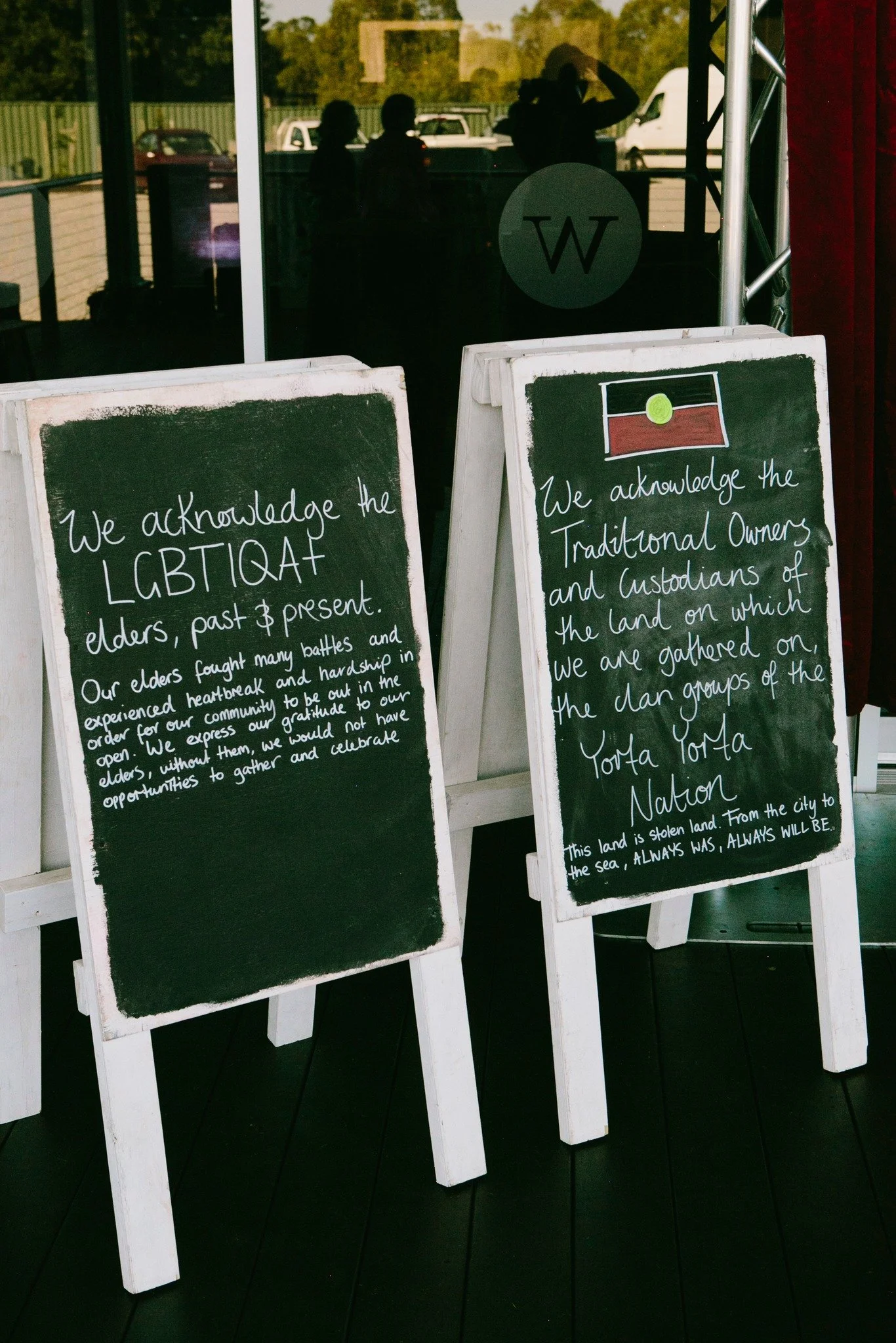A chalk board with a sign on it, displaying 'Pride Ball'