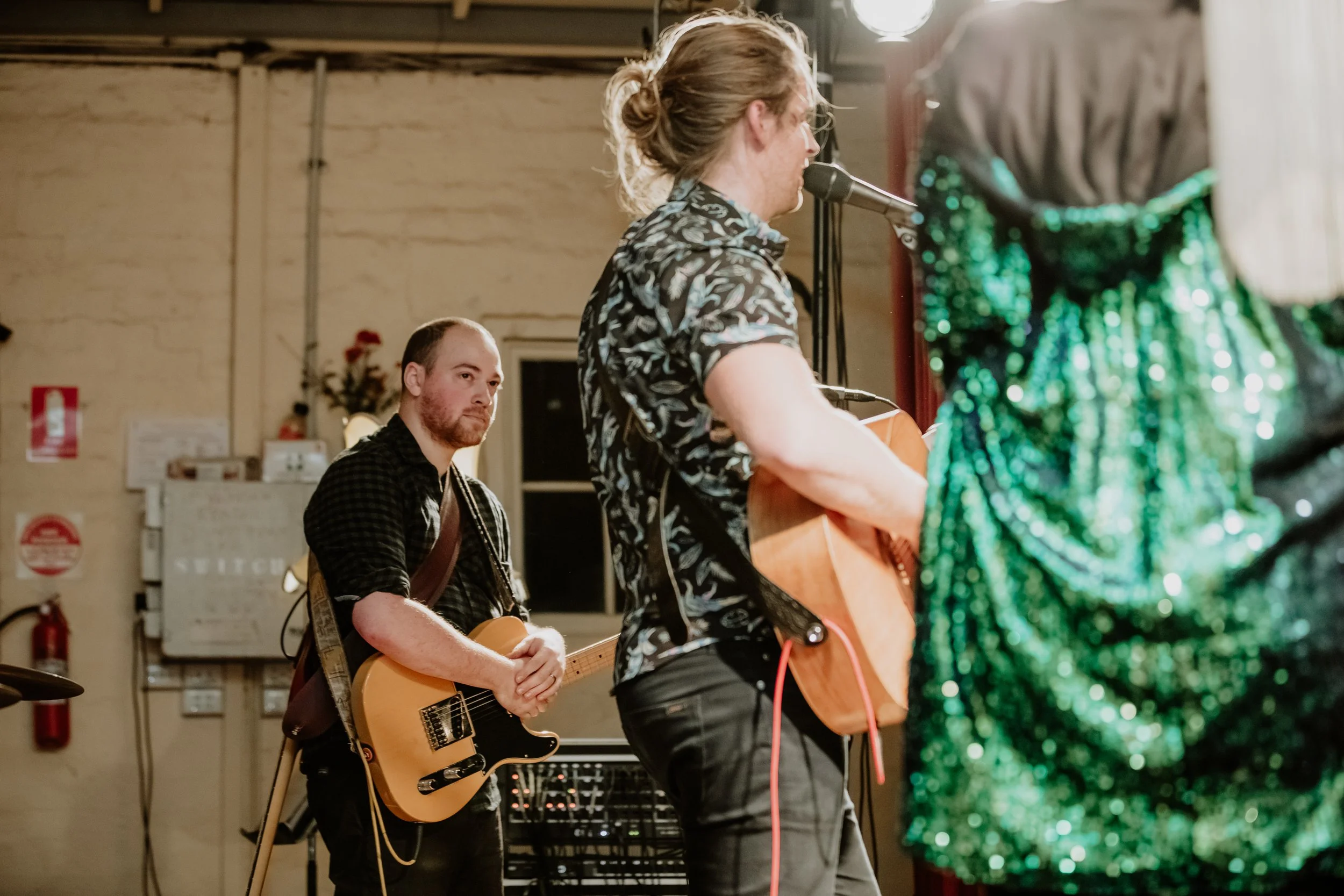 Two guitarists performing together.