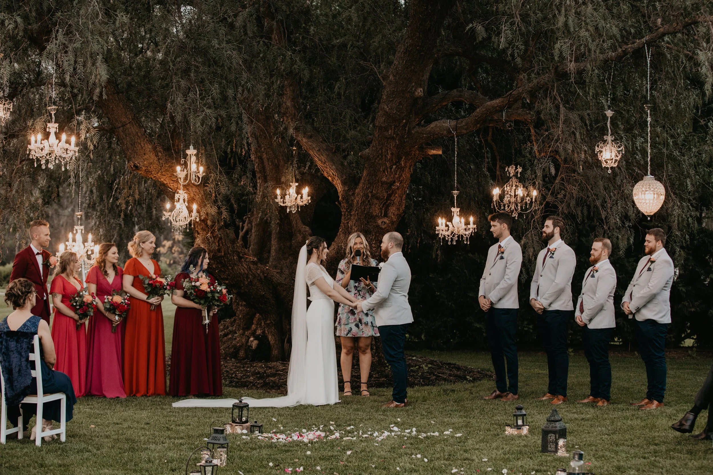 A beautiful wedding ceremony taking place at the Hurlstone Homestead, surrounded by lush greenery and colorful flowers.