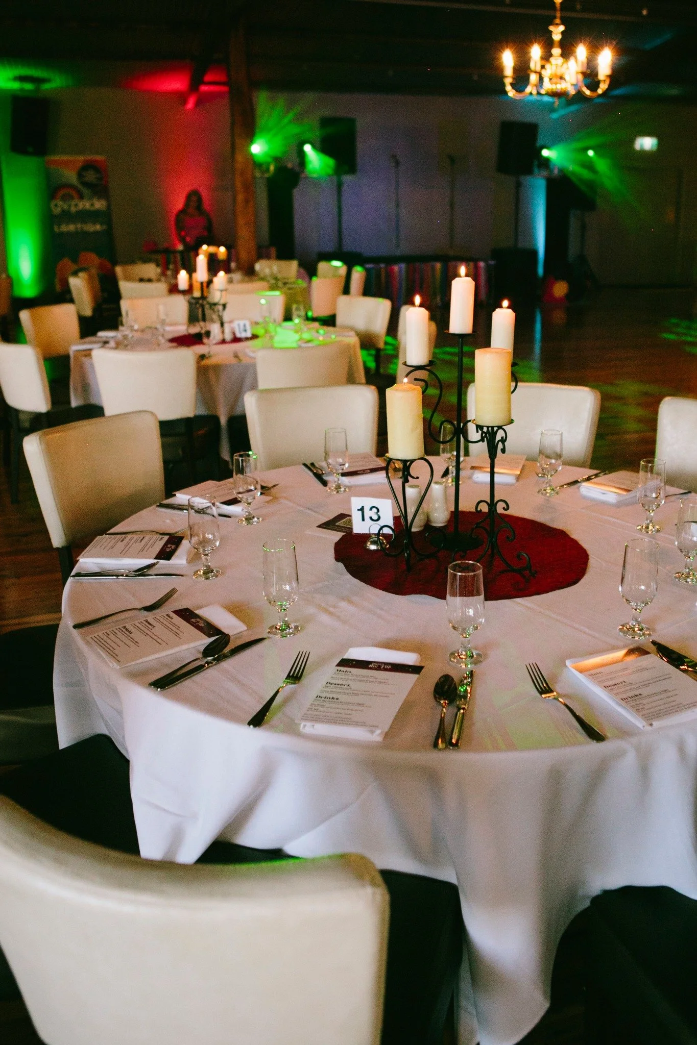 Gathering of white chairs around a round table adorned for the Pride Ball.