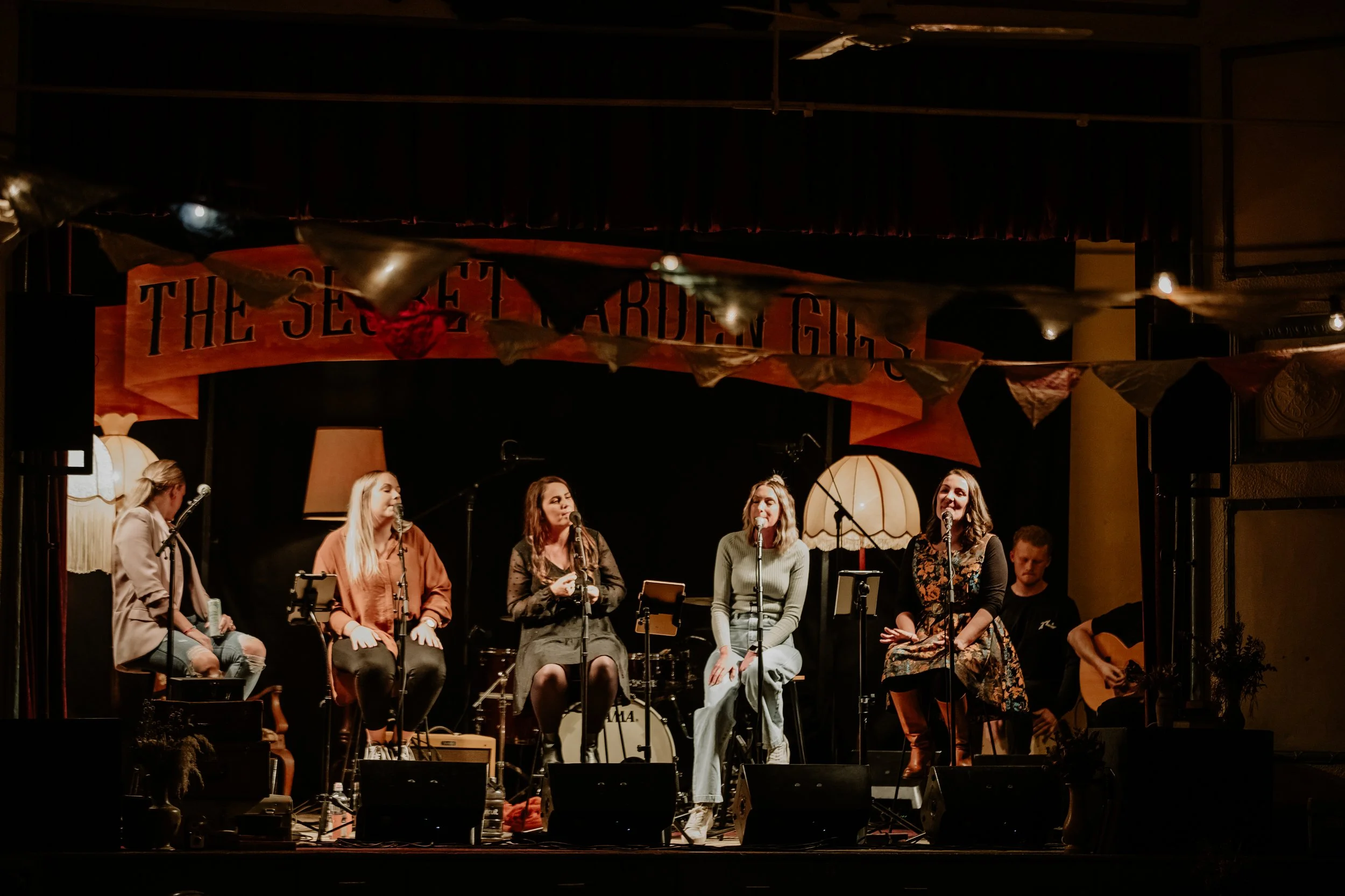 Five women singing in harmony at The Secret Garden Gigs.