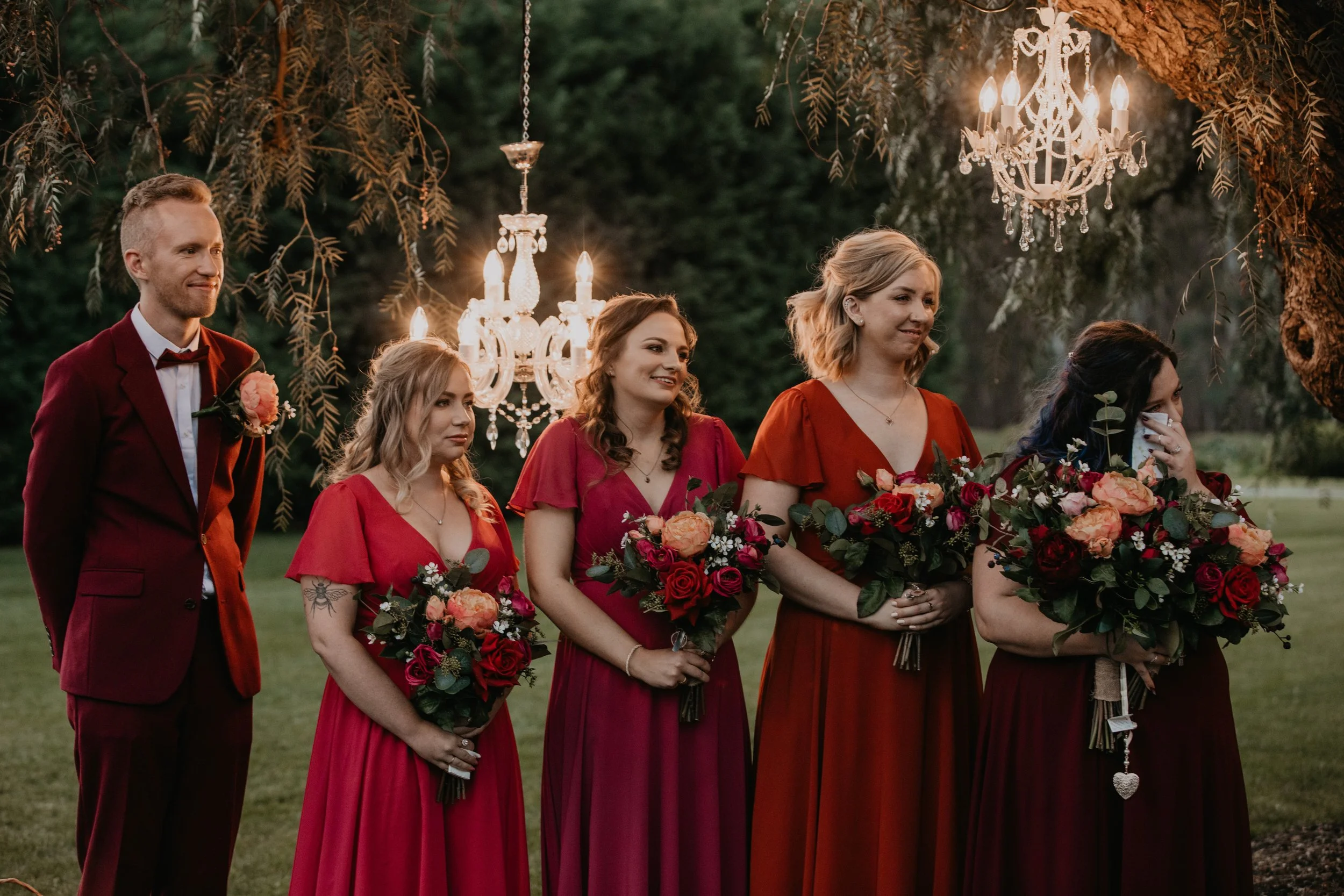 The Bridesmaids look at the couple happily, wiping away tears.