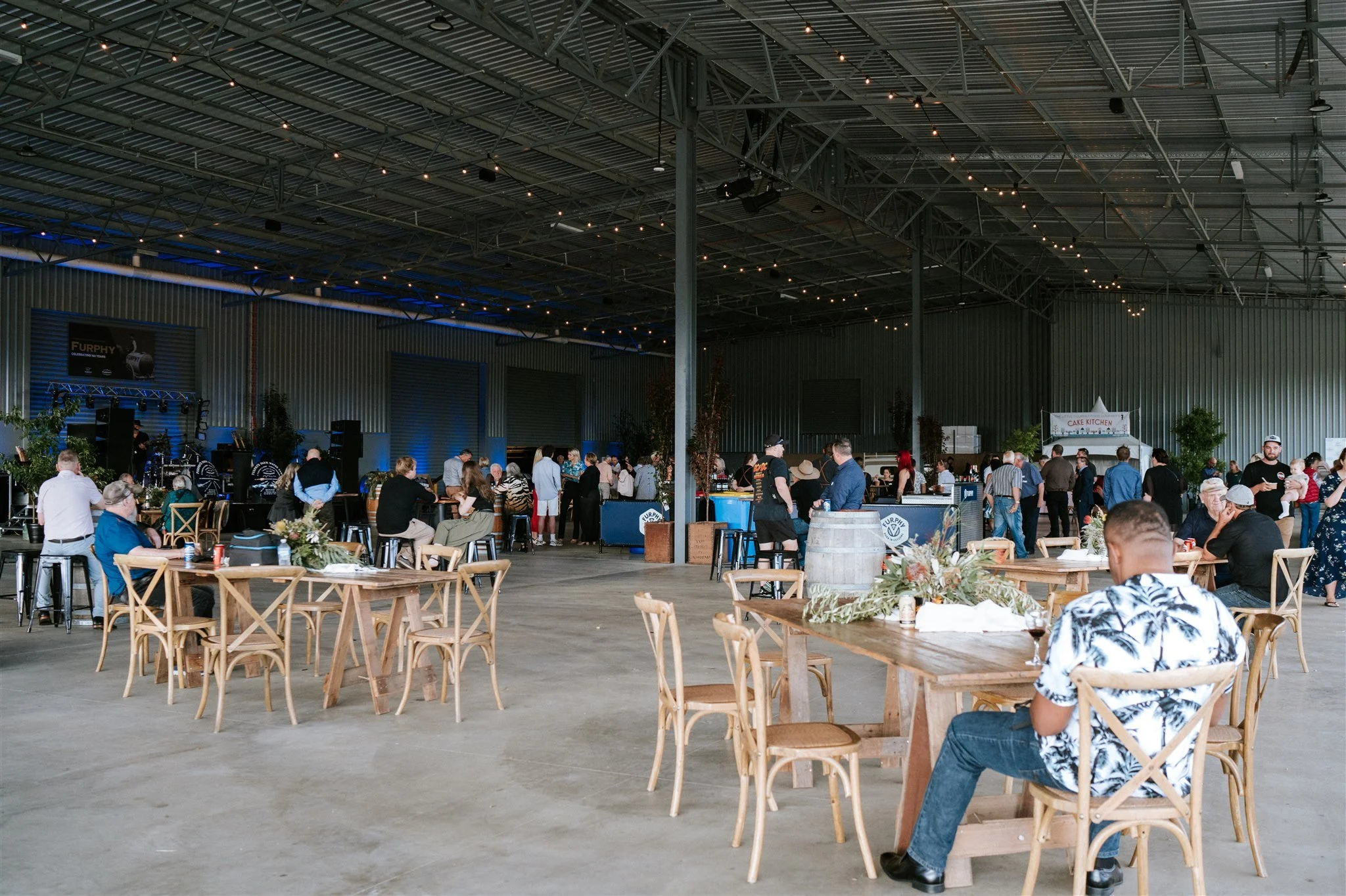 Attendees at Furphy 150 Year Celebration sit at tables in indoor event space.