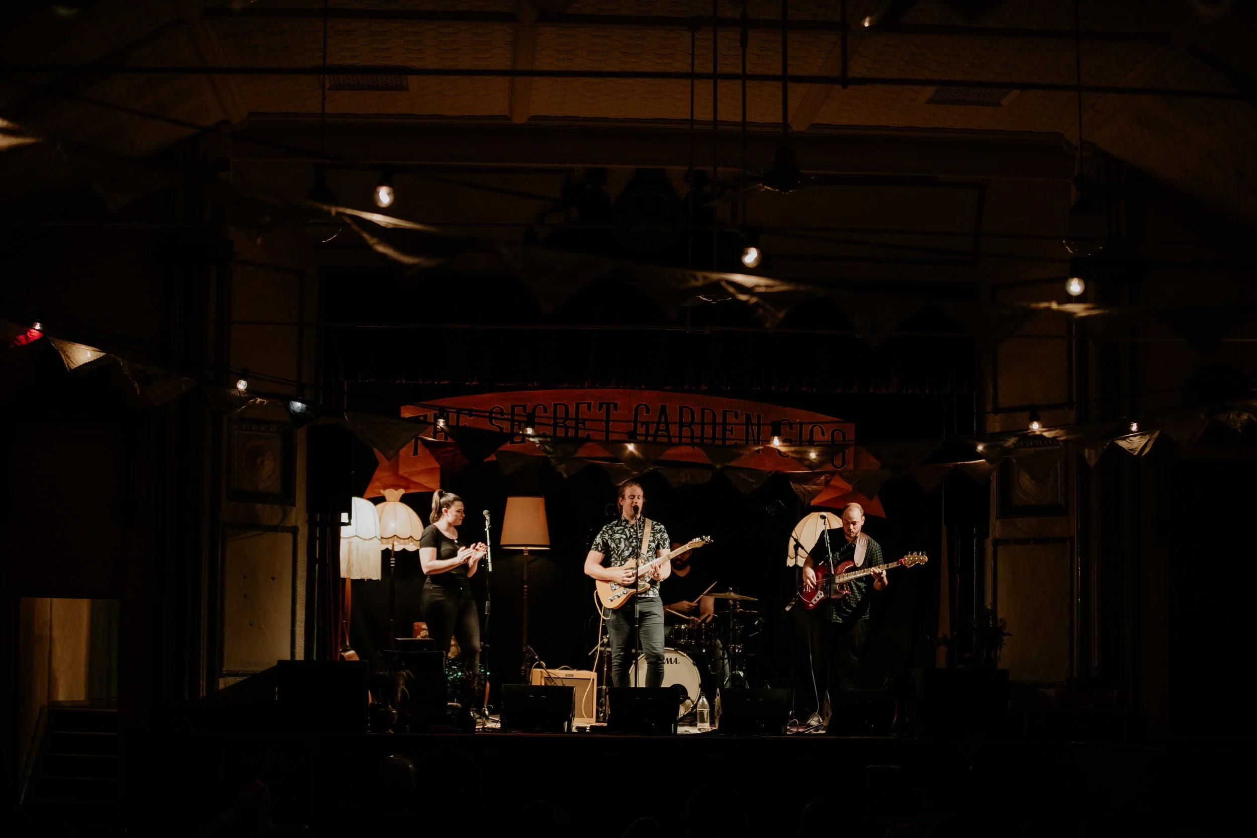 An acoustic band performing for the crowd at The Secret Garden Gigs.