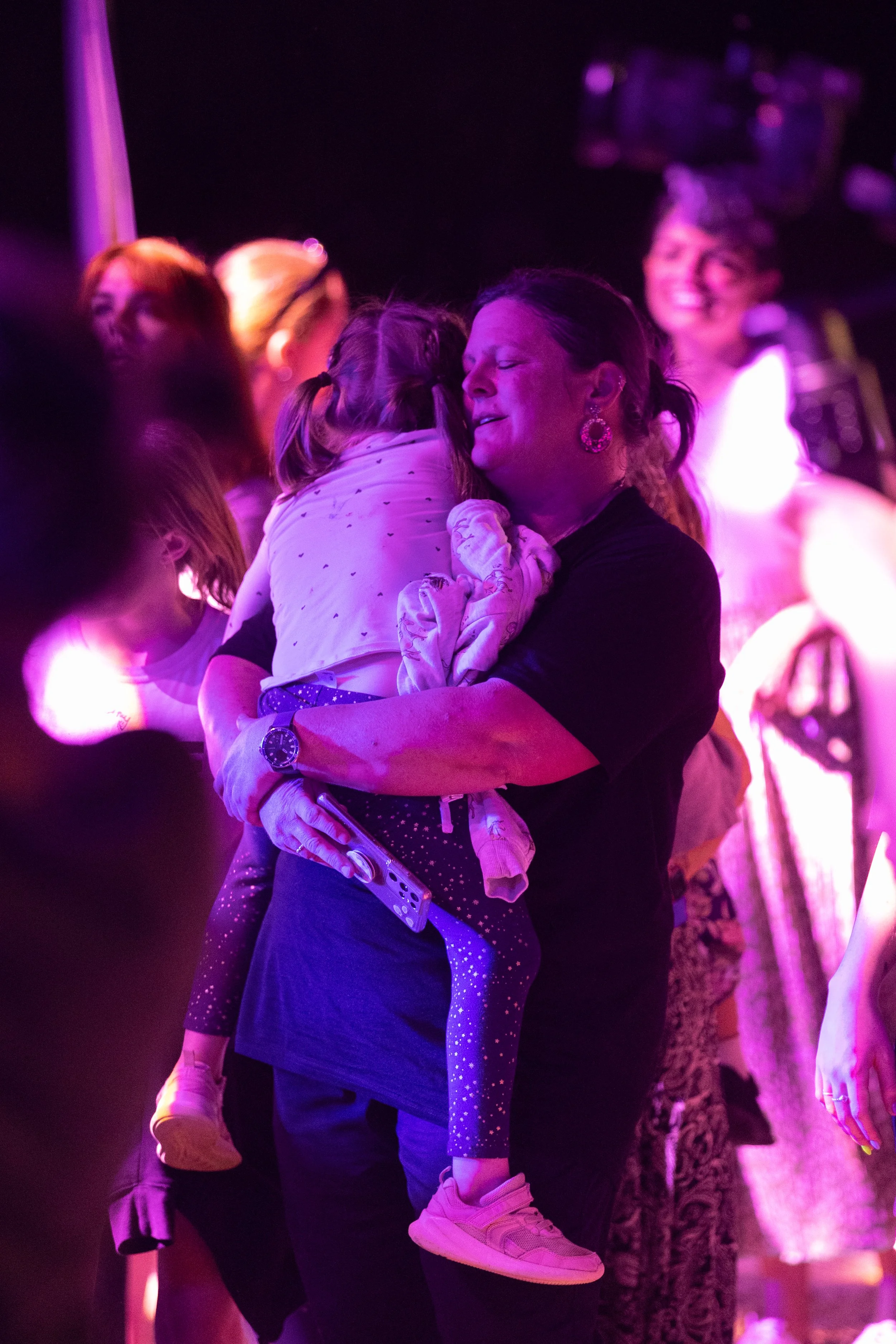 A woman hugging a child on the dancefloor.