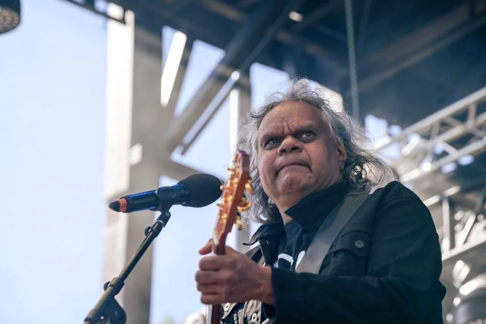 Guitarist with long hair performing live on stage.