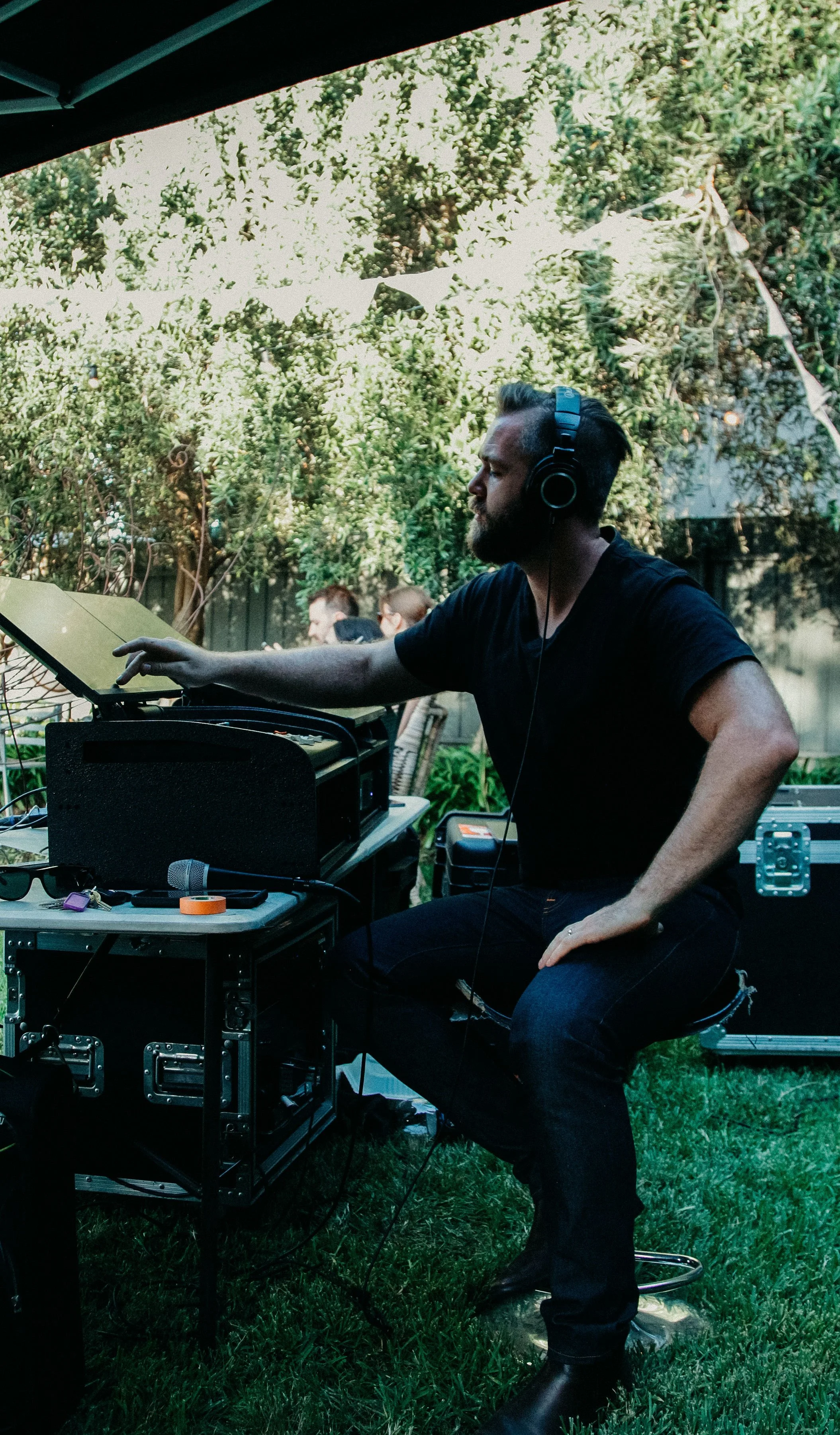 A person in black shirt and headphones, immersed in music.