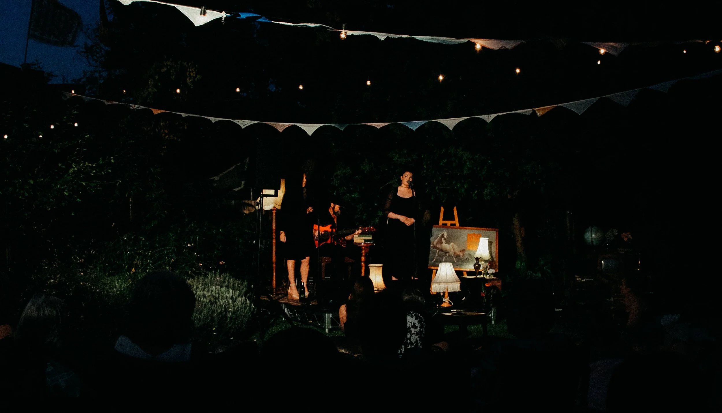 A woman confidently performs on stage, strumming a guitar with passion and skill.