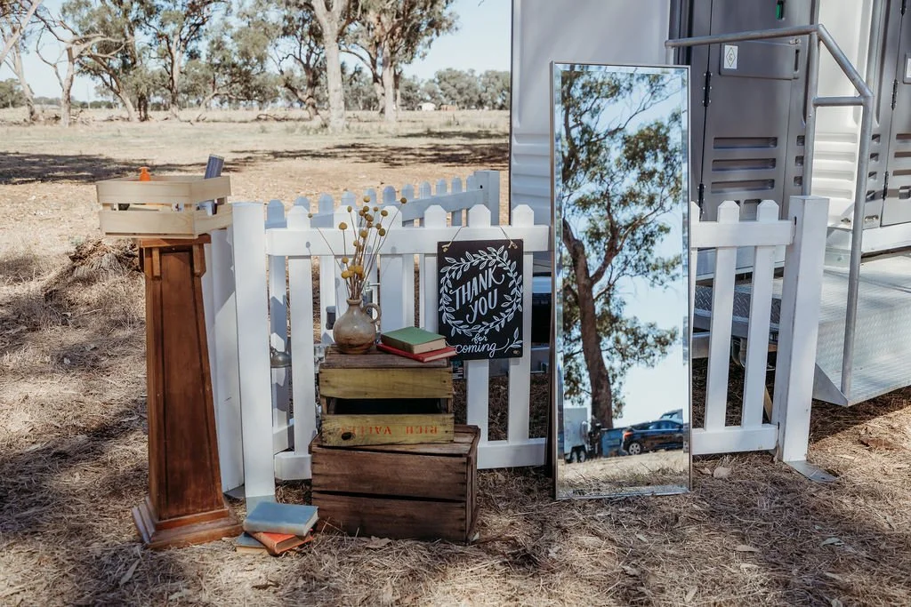 Rustic wedding decor featuring books, flowers, and a "thank you" sign.