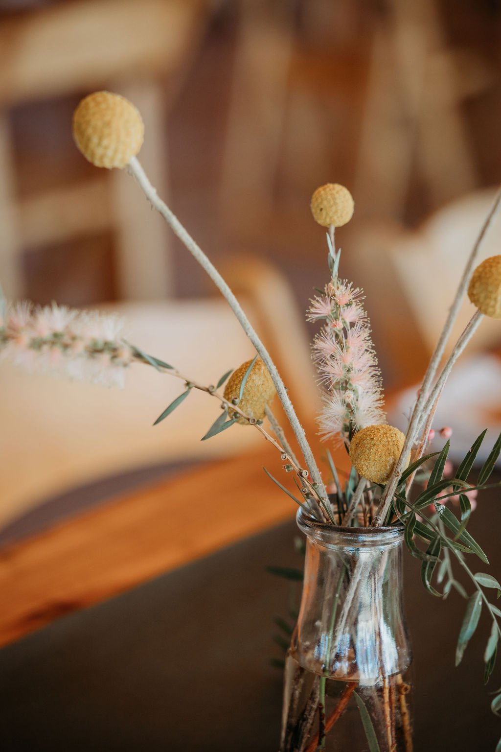 A rustic floral arrangement for a wedding, featuring a charming mix of flowers and foliage.