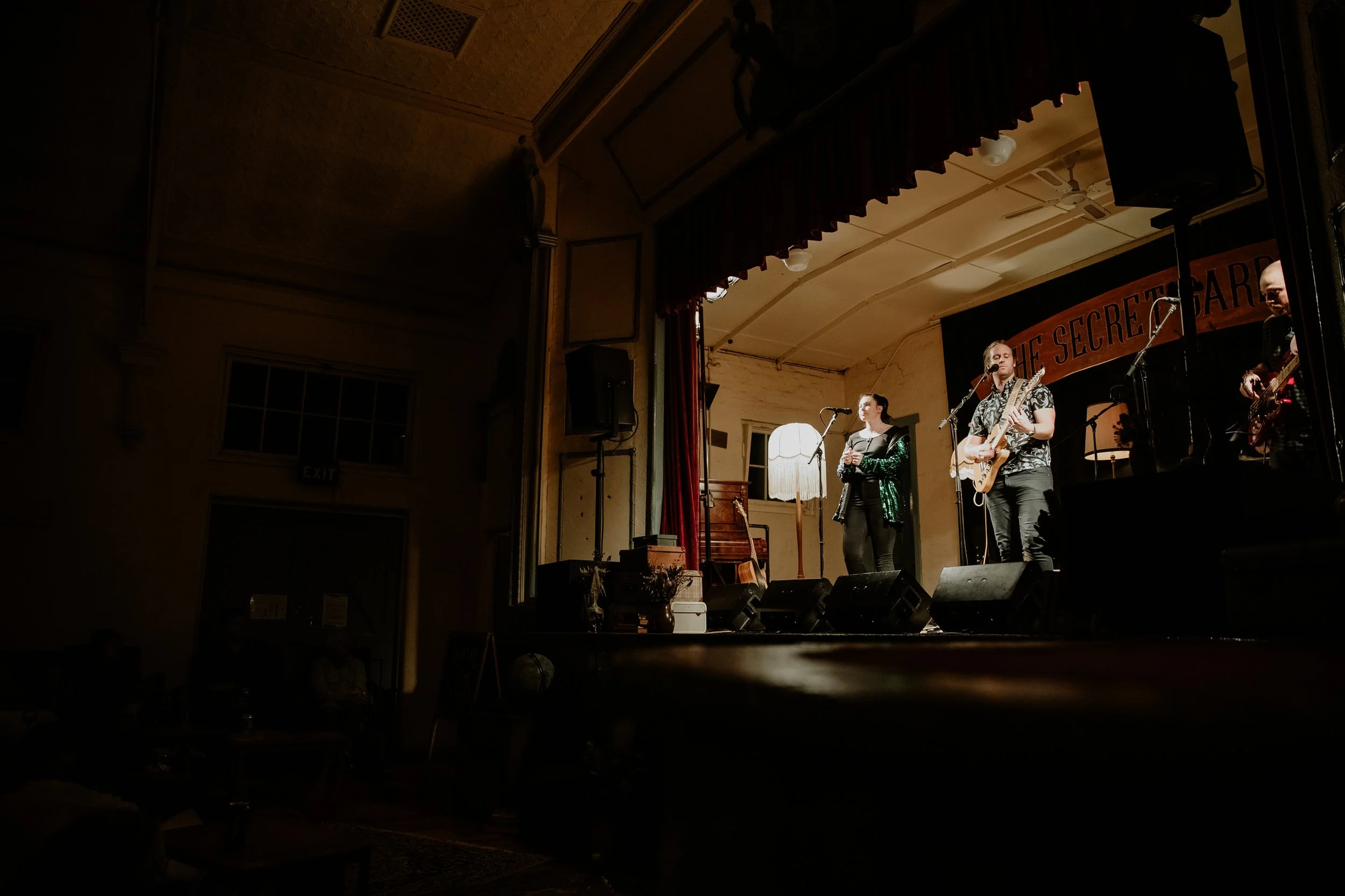 The stage for The Secret Garden Gigs, with a man and woman performing.