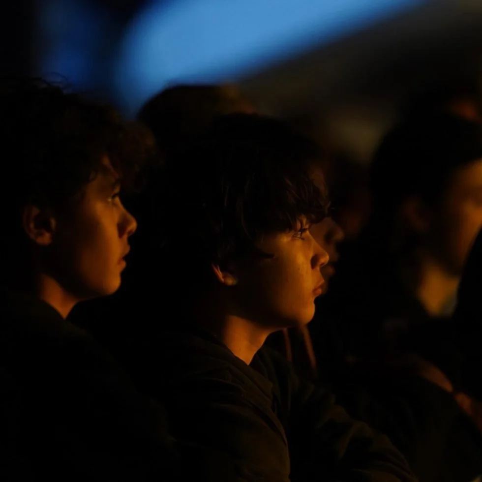 Audience members seated in darkness at a concert venue for Treaty Day Out.