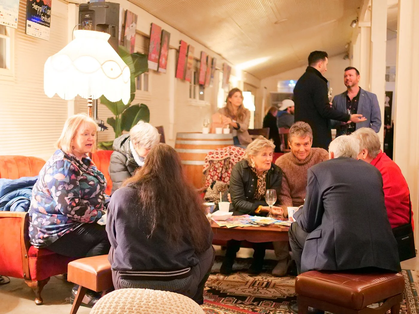 A group of people sitting on vintage couches, enjoying lively discussion.